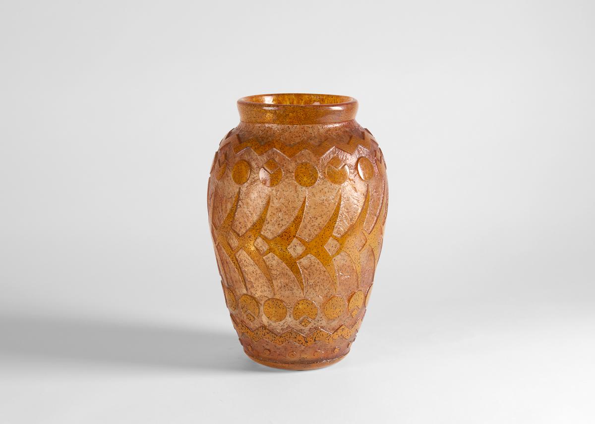 This large, urn-shaped vase is a dark amber color and decorated in an acid-etched relief pattern.