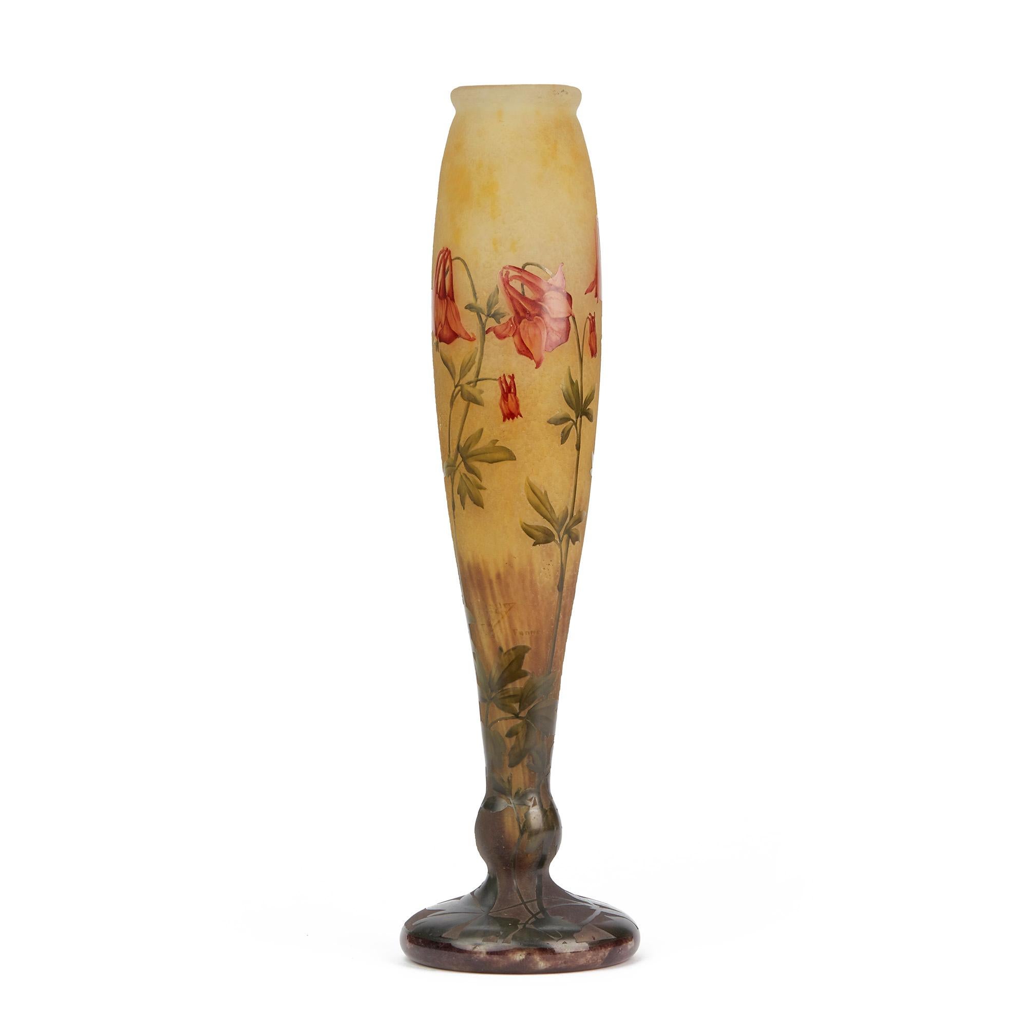 An exceptional French Art Nouveau Daum Frères Columbines cameo glass vase wheel cut with raised designs in colored enamels on an etched ground Dating from circa 1910. The tall slender bodied vase stands on a wide rounded foot cut with leaves and is
