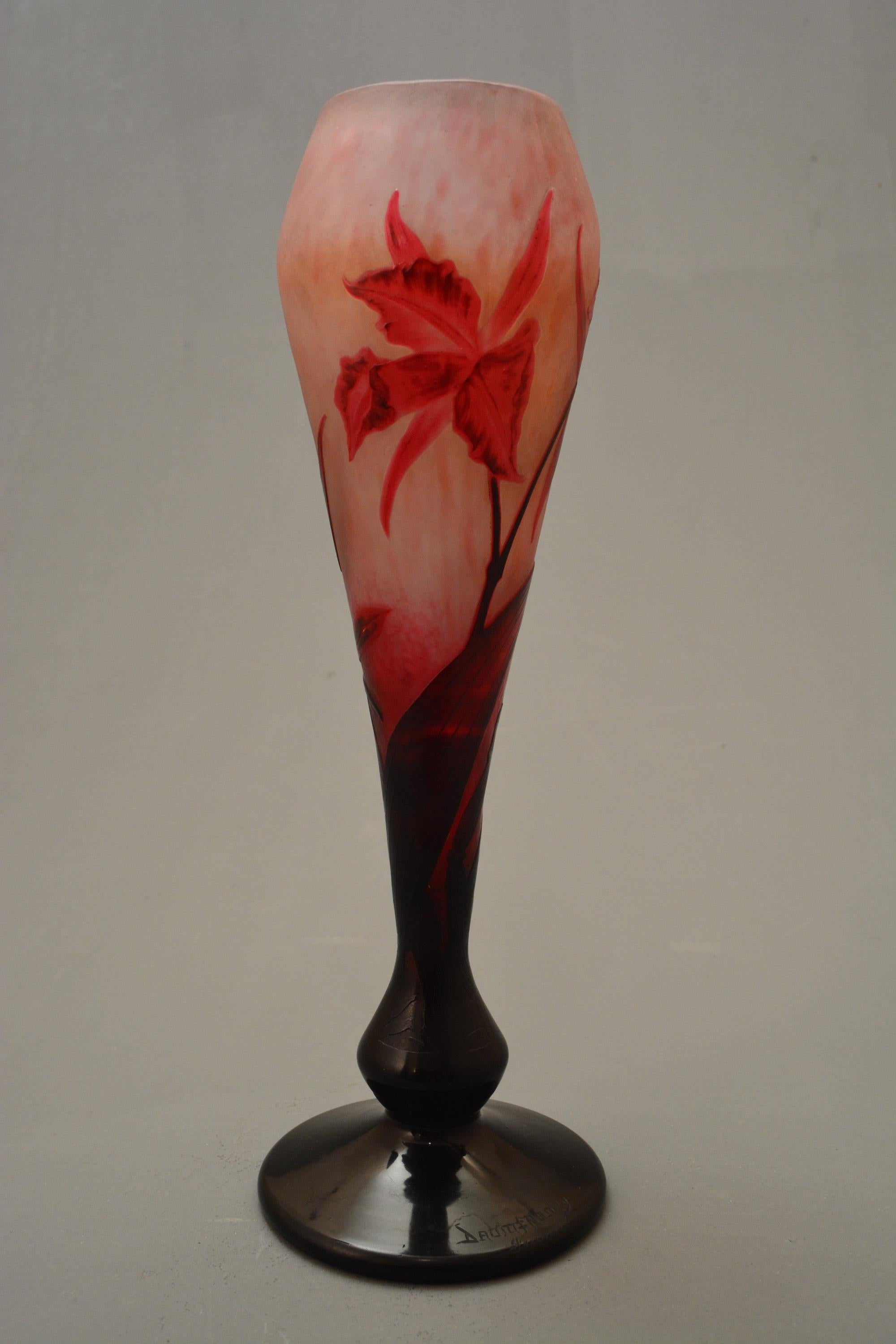 Double overlay, etched, wheel carved and partially martelè glass vase of spreading footed form, the pink marbled martelè ground overlaid in reddish purple with a cattleya labiata decoration.
Daum production.
Signed Daum-cross of