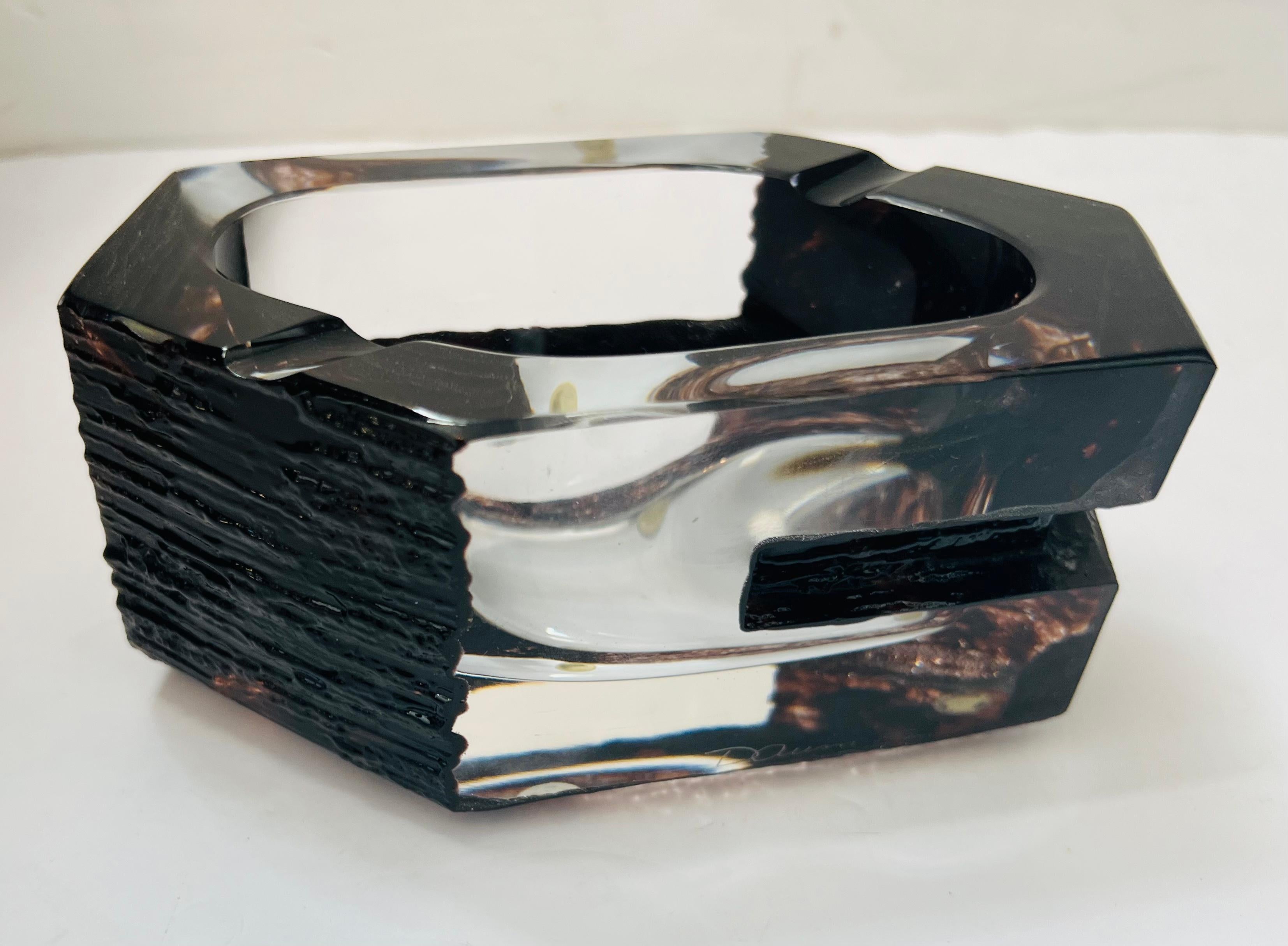 A great sculptural thick black and clear smoked crystal ashtray bowl in a brutalist style by the famed French artist Cesar Baldaccini for Daum. Signed. Excellent unused condition.
