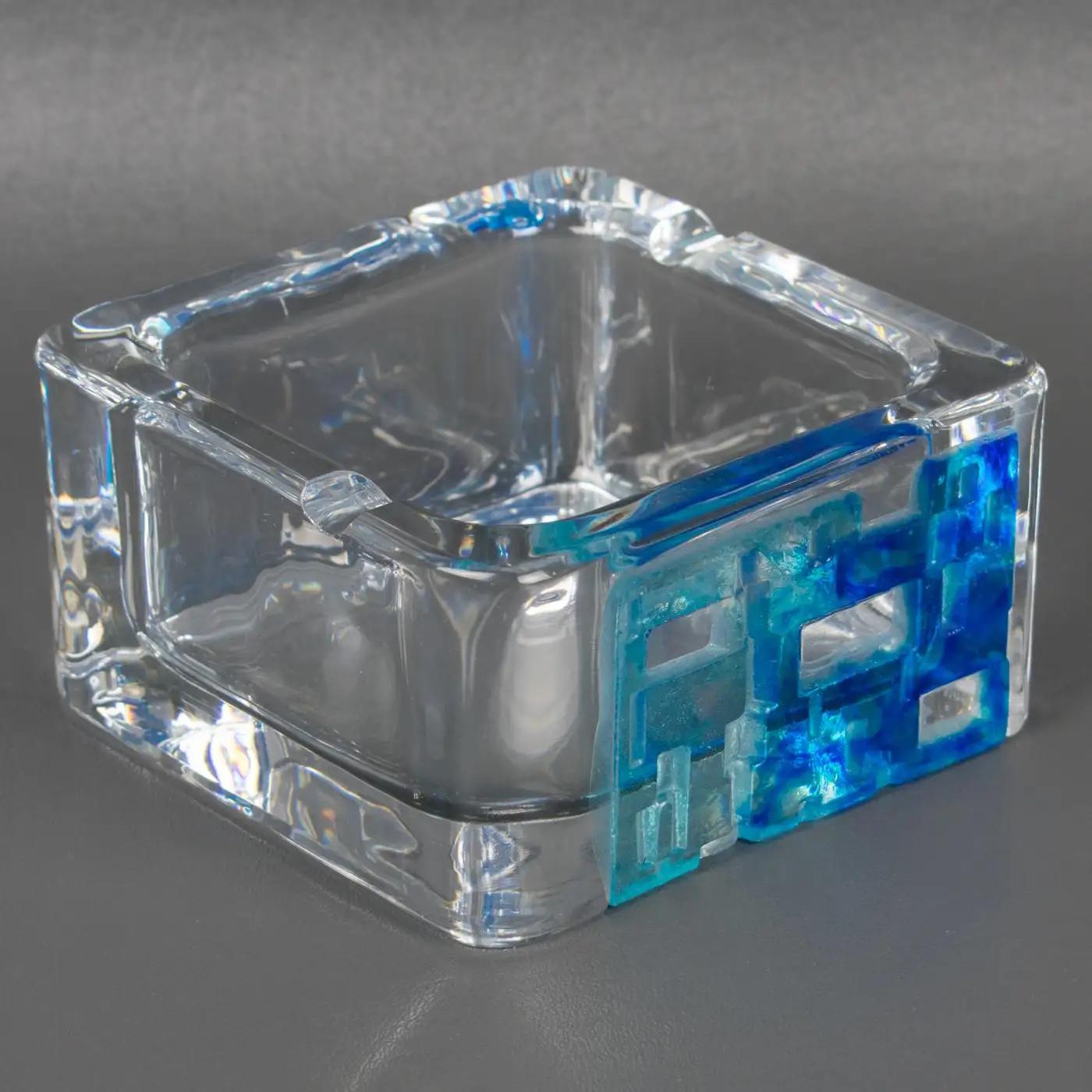 Daum France designed this lovely crystal ashtray, catchall, or decorative bowl in the 1970s. The mouth-blown transparent crystal design has a heavy square shape with blue and turquoise modernist pate de verre inlay. The desk tidy is marked on the