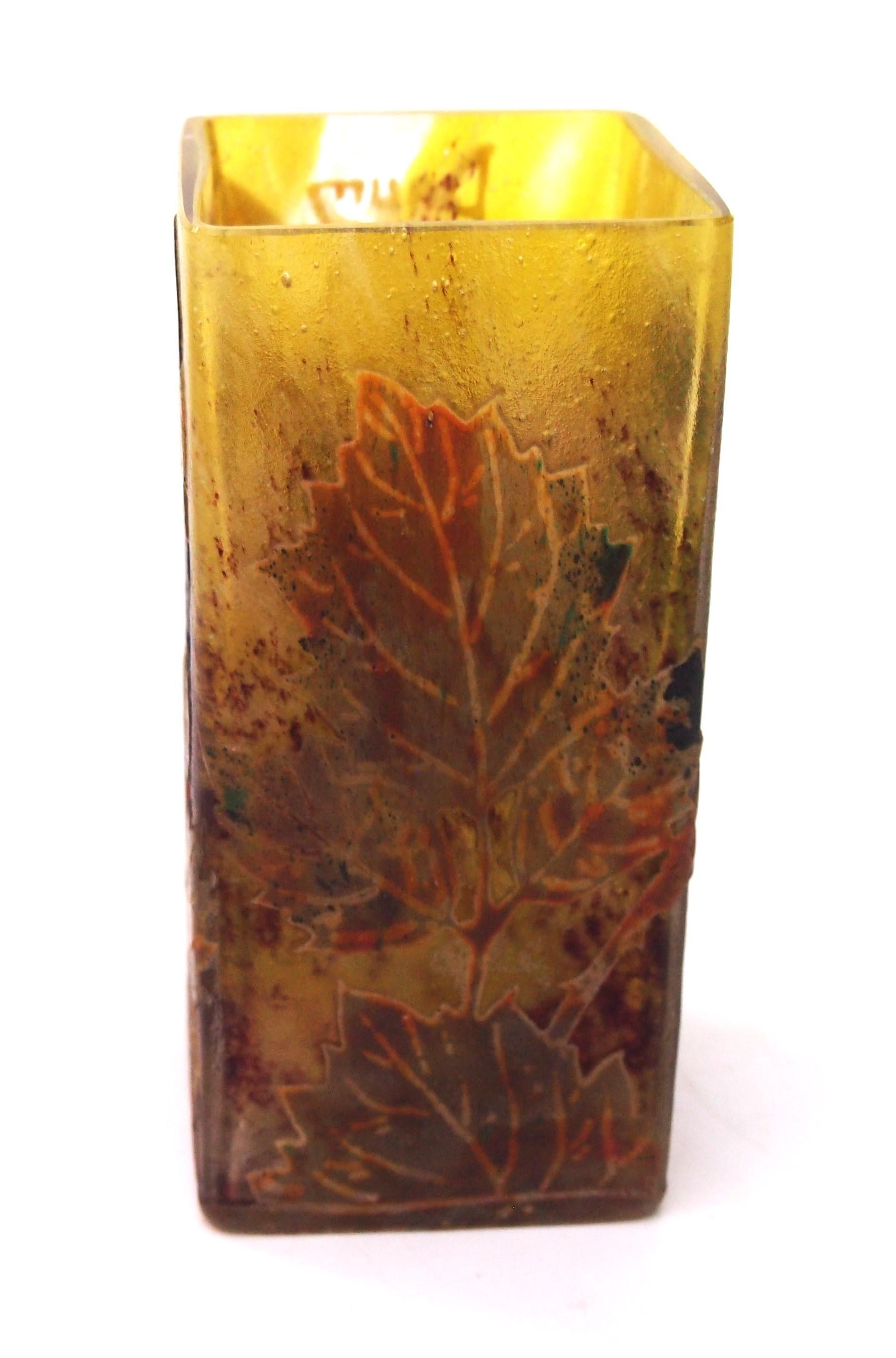 Vaso a sezione quadrata con more autunnali estremamente bello e classico di Daum - smaltato in policromia e con taglio a cammeo raffigurante un mix di piante autunnali a foglie grandi con grappoli di more mature.  La classica forma a sezione