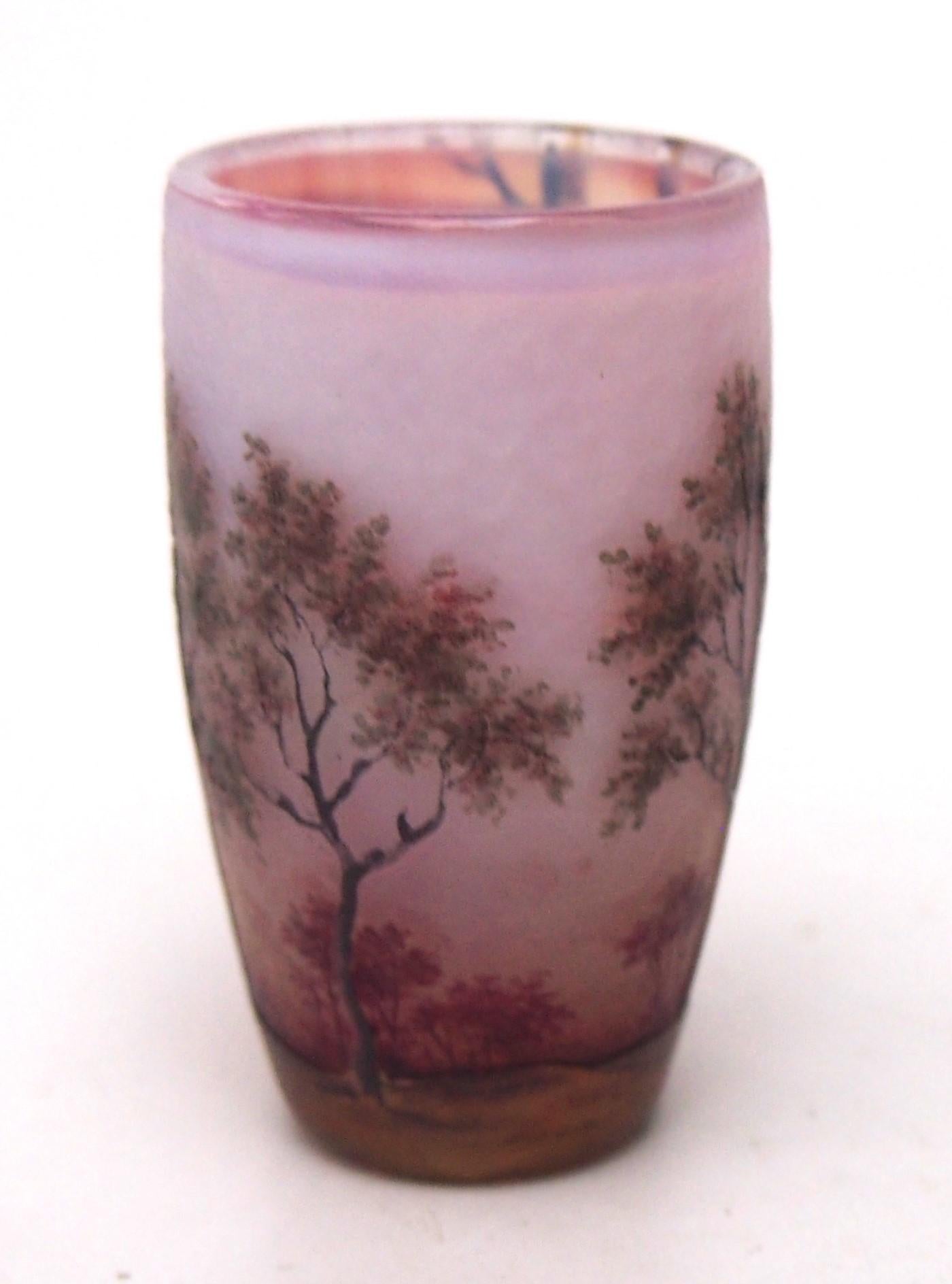 Miniaturnahe Vase Daum Spring Scene - polychrom emailliert und mit Kamee, die eine frühlingshafte Waldszene mit neu austreibenden Bäumen vor einem rosafarbenen Sonnenaufgang am frühen Morgen darstellt.  Er hat die Größe eines großen Fingerhuts.