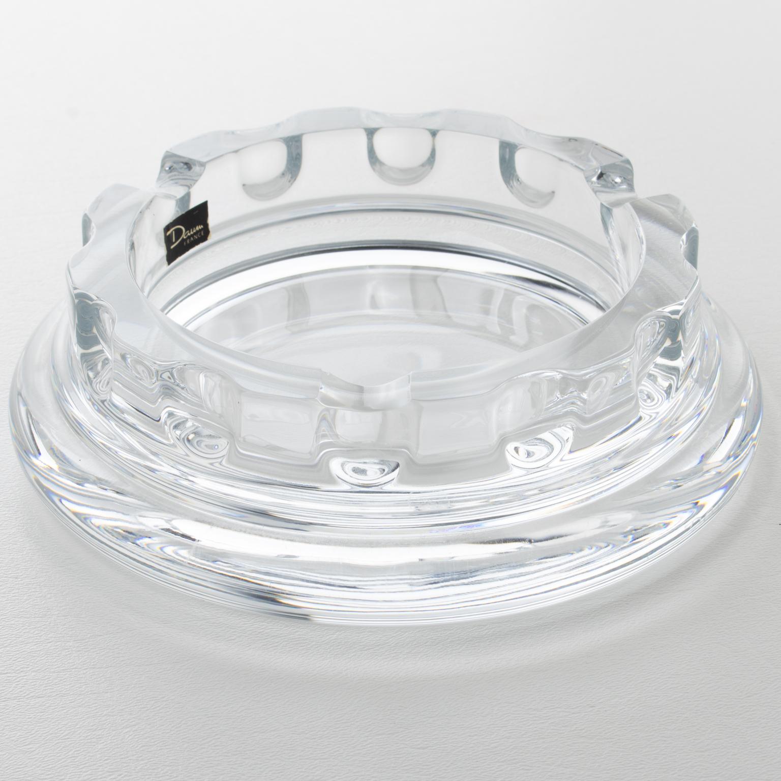 Daum France designed and crafted this elegant crystal cigar ashtray, catchall, or decorative bowl in the 1970s. The mouth-blown clear crystal is heavily carved with a round, weighty shape. The vide poche is marked on the side edge with the