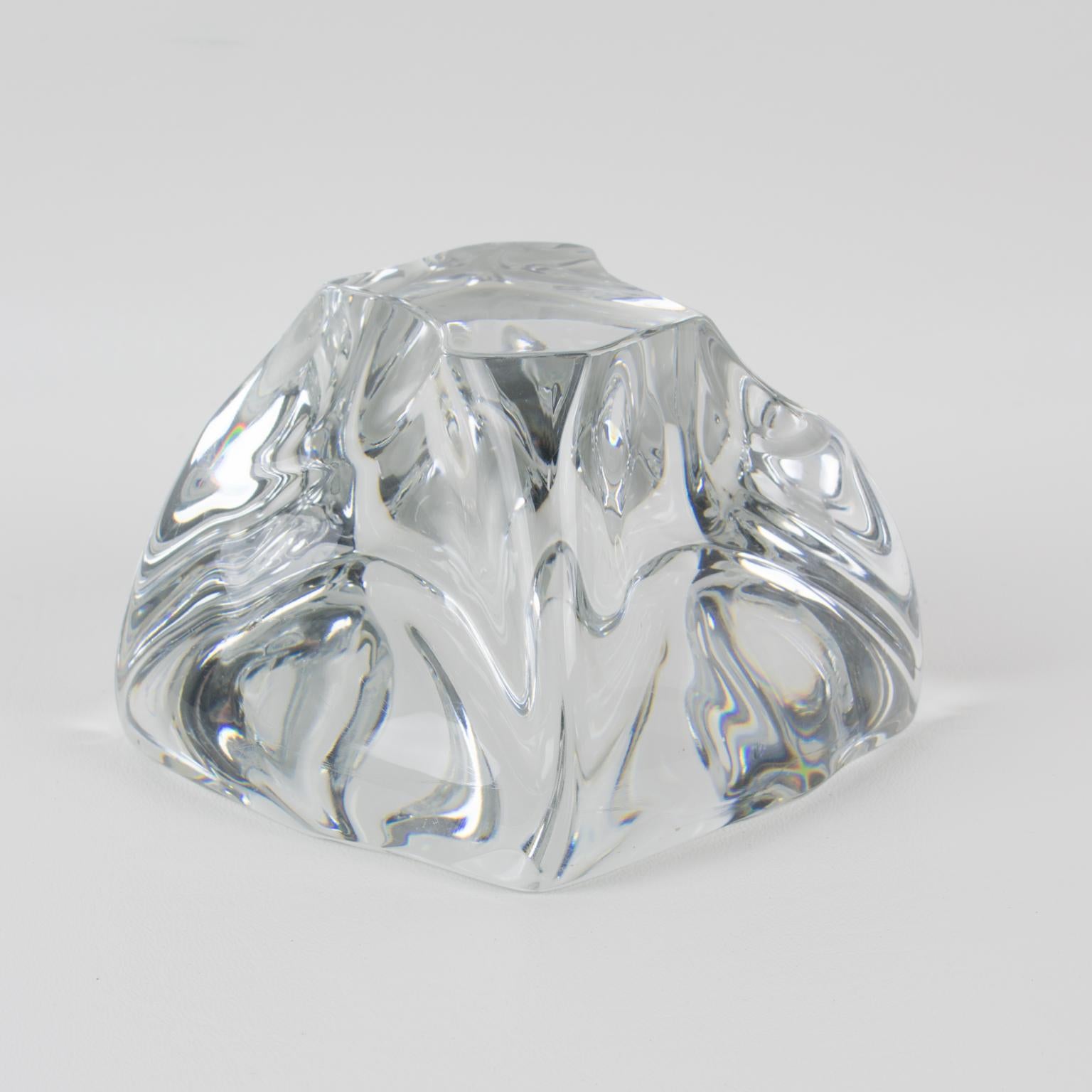 This stunning crystal abstract freeform desktop paperweight is by Daum, France. The sculpture features a French design of the 1950s with a mouth-blown clear crystal in an abstract figure in a curved swirl-like form. The piece is engraved on the side