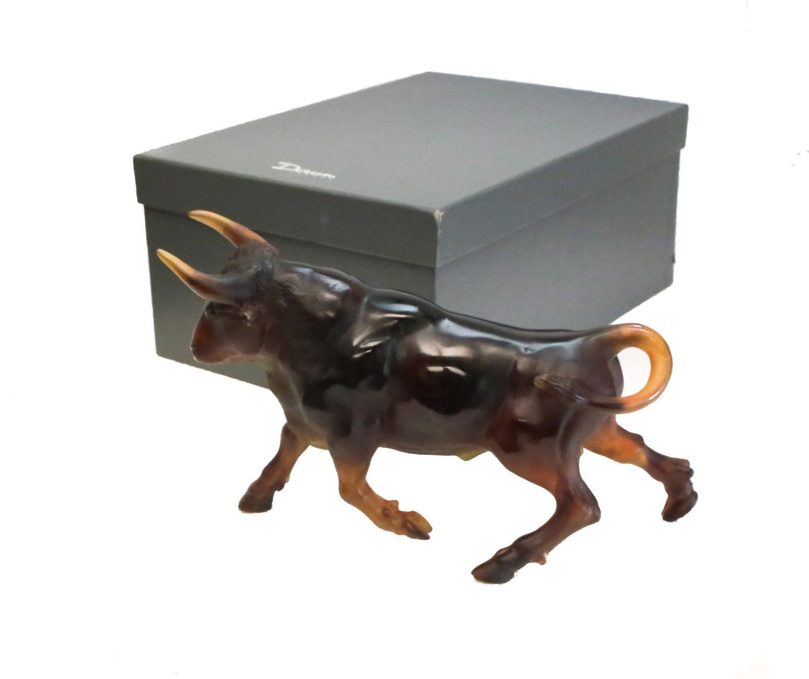 A charming Daum France Pat-de-Verre multi-colored bull figurine in original box. The figurine transitions from brown to amber to the bull's feet. Incised 