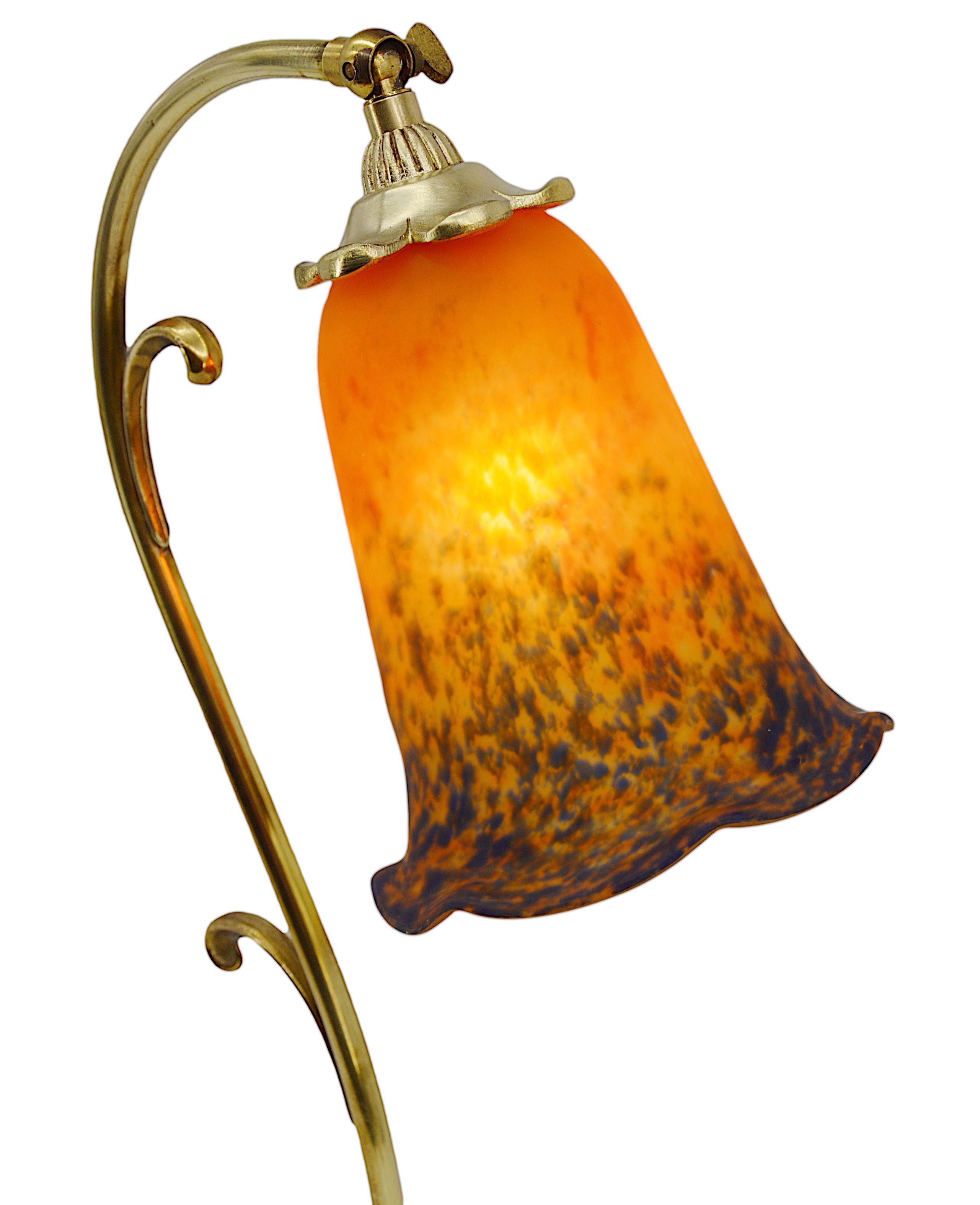 French table lamp by Daum (Croismare), France, ca.1925. Blown double glass shade by Daum hung at its swiveling bronze base. Colors : red, orange & dark blue. Measures: Height: 18.9