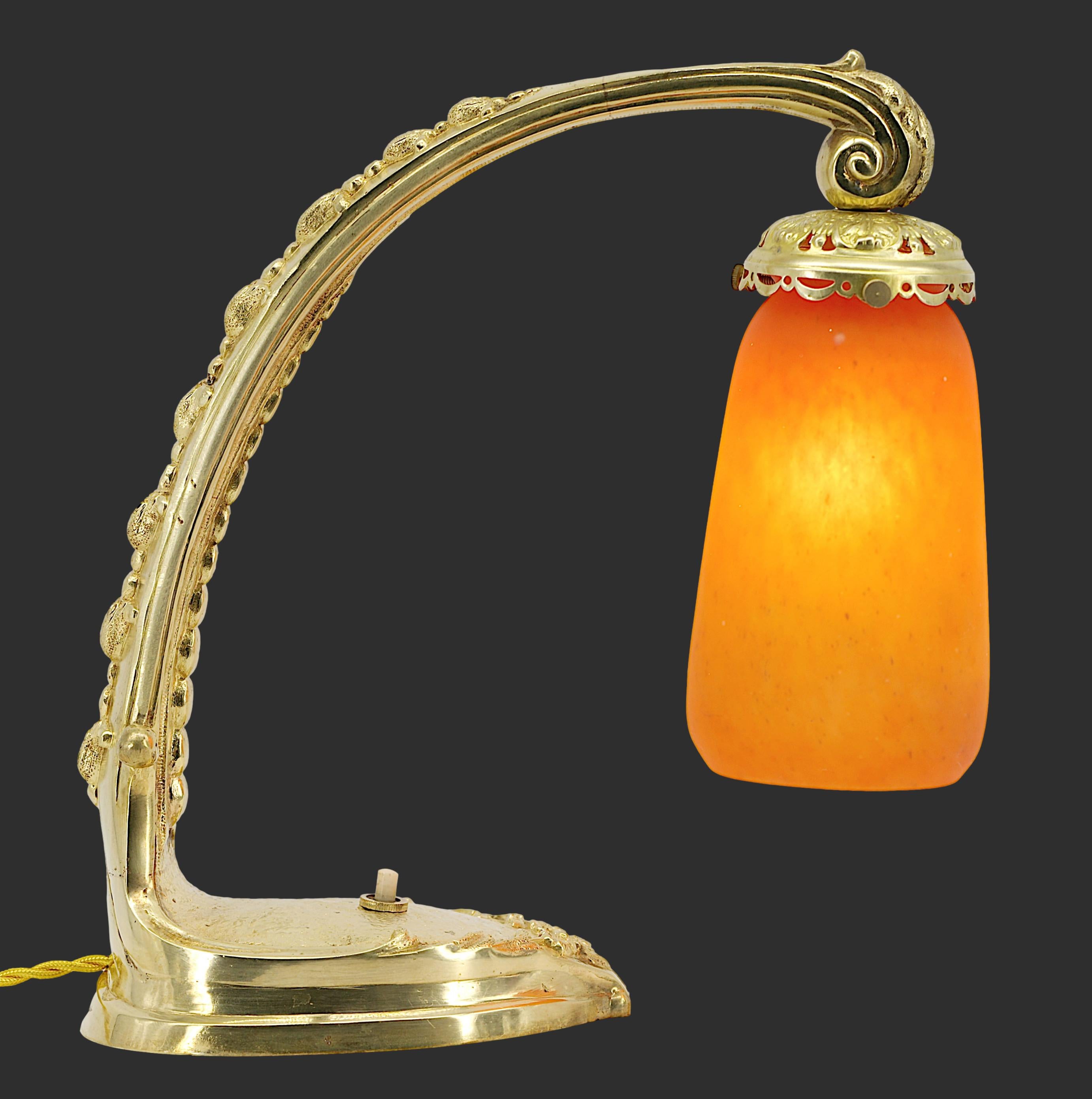 Lámpara de sobremesa de Daum (Nancy), Francia, hacia 1915. Esta elegante lámpara presenta una hermosa pantalla de cristal fabricada por Daum, suspendida de una base de bronce macizo finamente cincelada. La altura es de 27 cm (10,6 pulgadas), con una