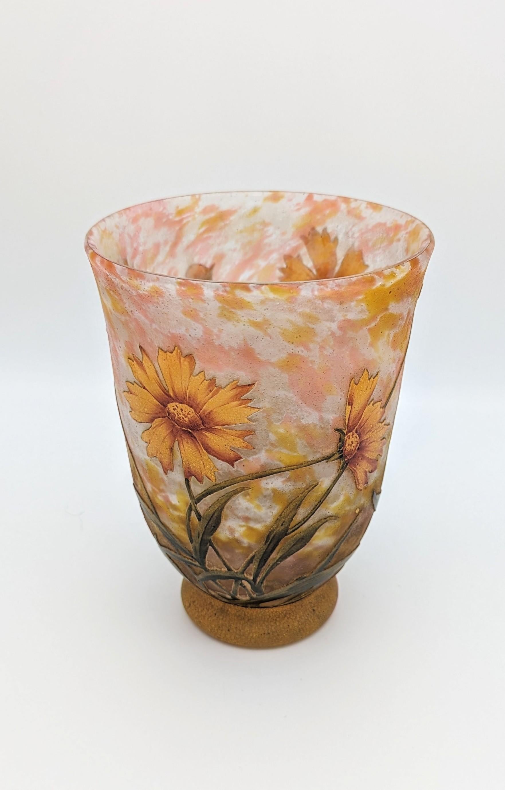 Un bel vaso Daum Frères con fiori di Coreopsis, prodotto a Nancy, Francia, circa 1914. Questo esemplare di vetro cammeo francese è stato screziato con polvere di vetro, incamiciato con un rivestimento, quindi inciso con acido e smaltato. Si tratta