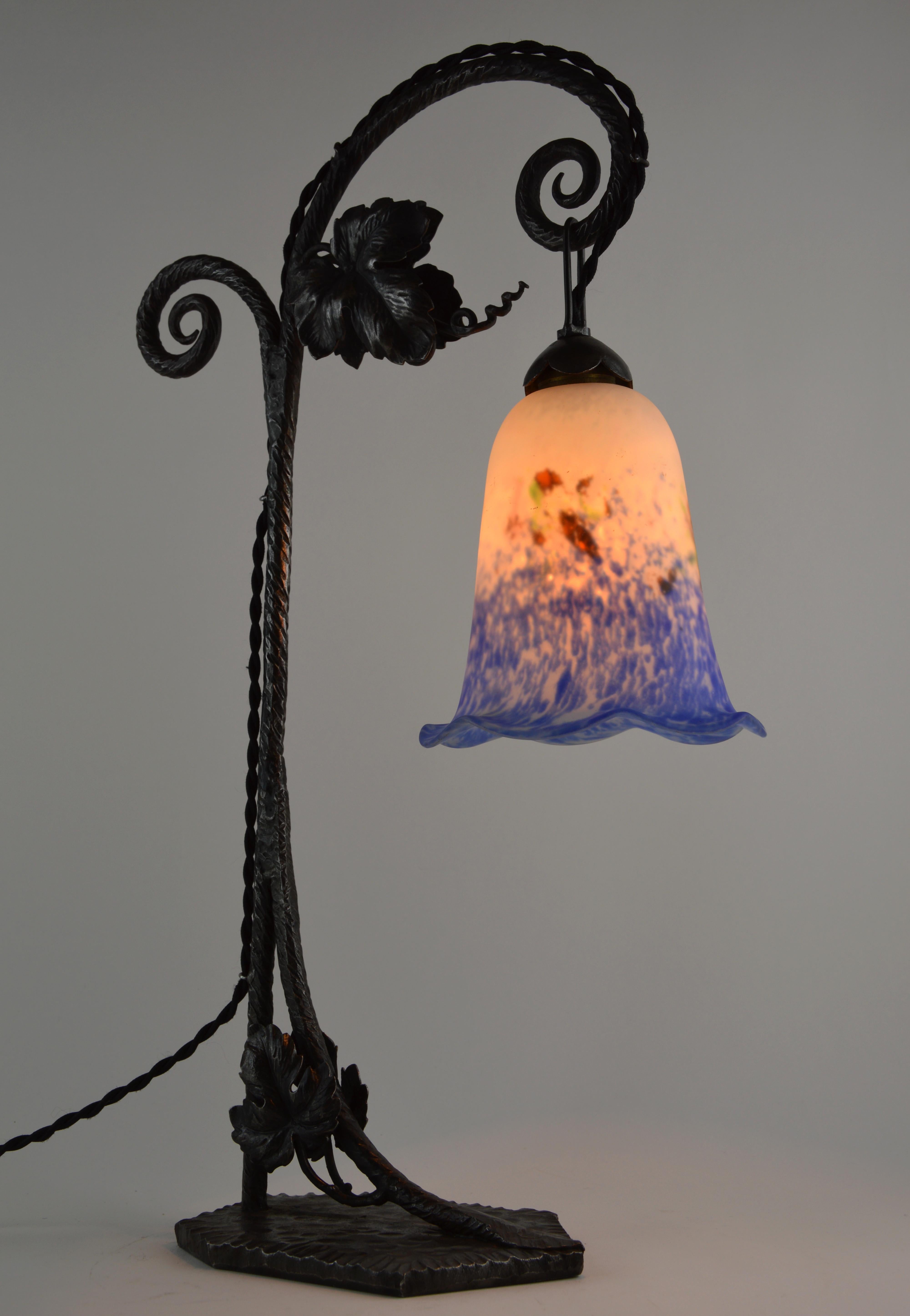 French Art Deco table or desk lamp by Daum (Croismare, Nancy), France, late 1920s. Blown double glass shade hung at its wrought iron base. Colors: blue, white, ochre, green and pink. Five colors for this beautiful shade. Enameled signature 