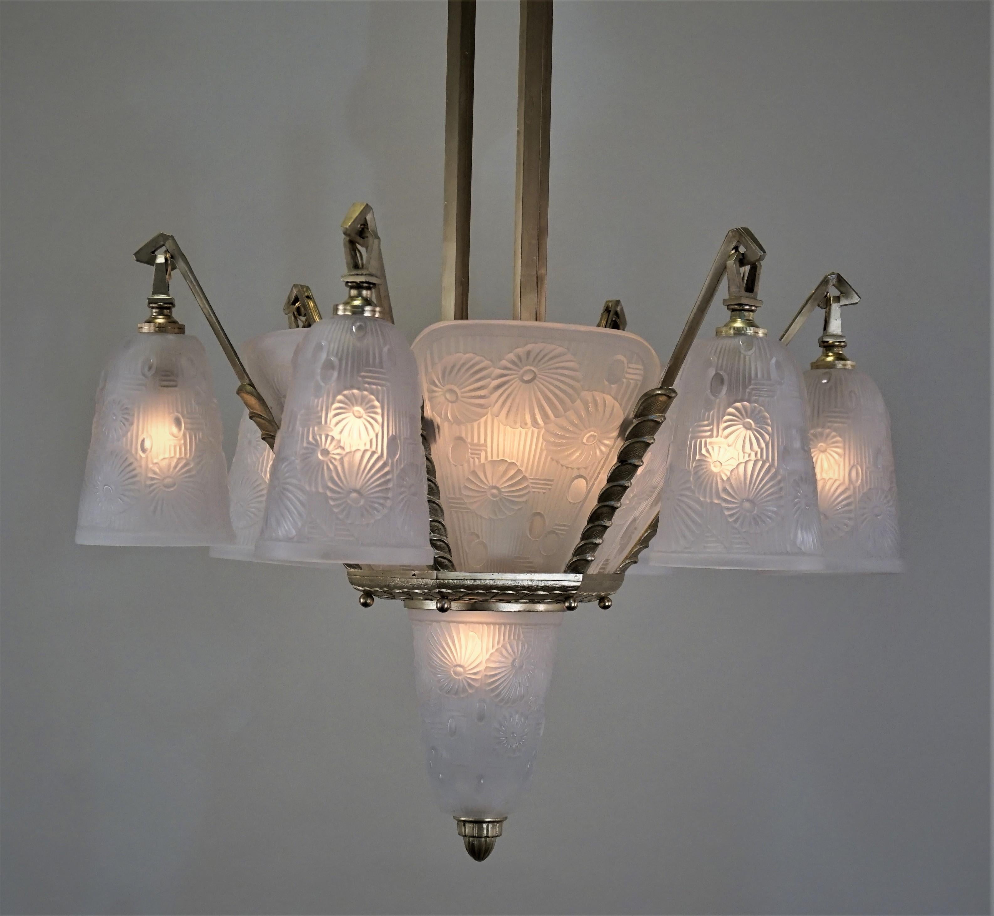 Modern flora design clear frost glass by Daum under name of Lorrain Nancy in late 1920s-early 1930s with fantastic bronze frame Art Deco chandelier.
Total of 13 lights, 60 watt max each.