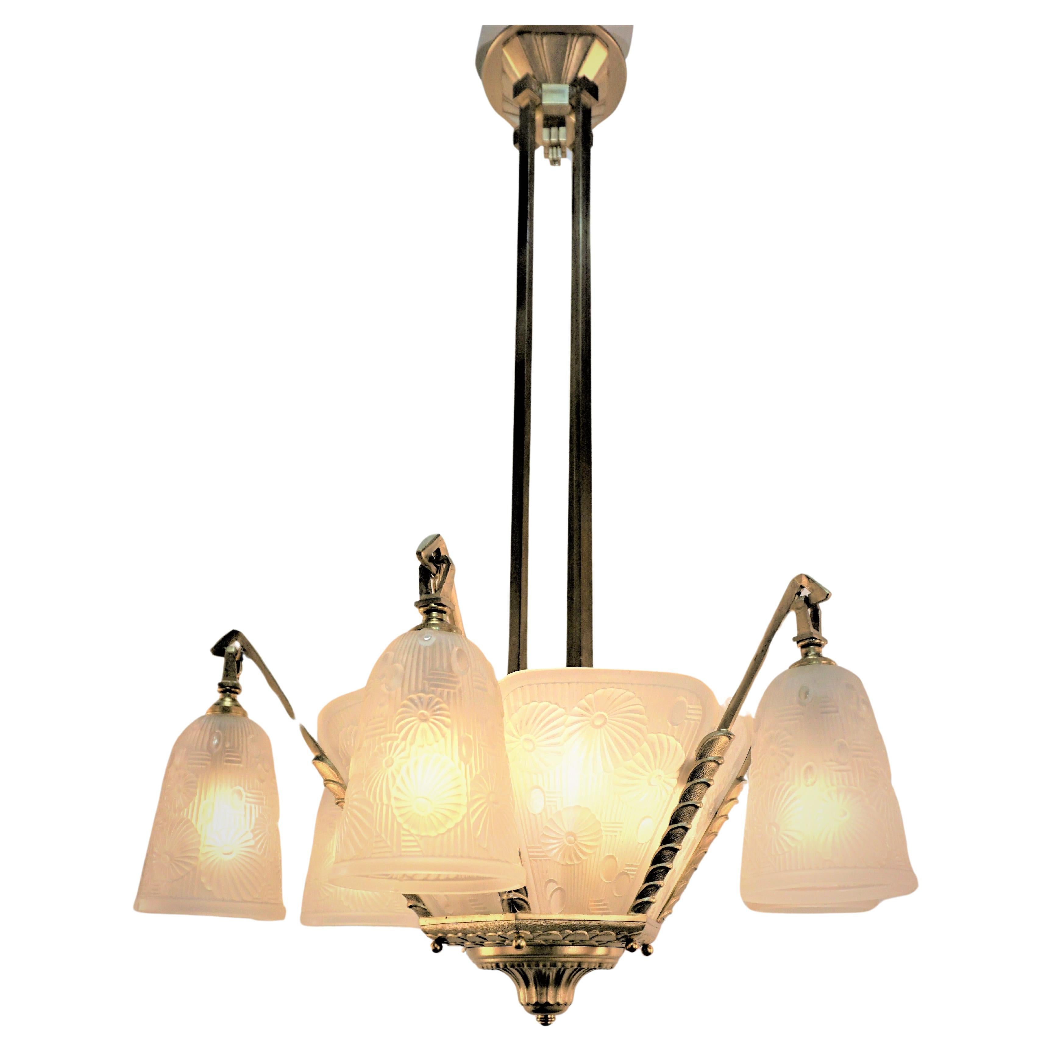 Modern flora design clear frost glass by Daum under name of Lorrain Nancy in late 1920s-early 1930s with fantastic bronze frame Art Deco chandelier.
Total of 12 lights, 60 watt max each.