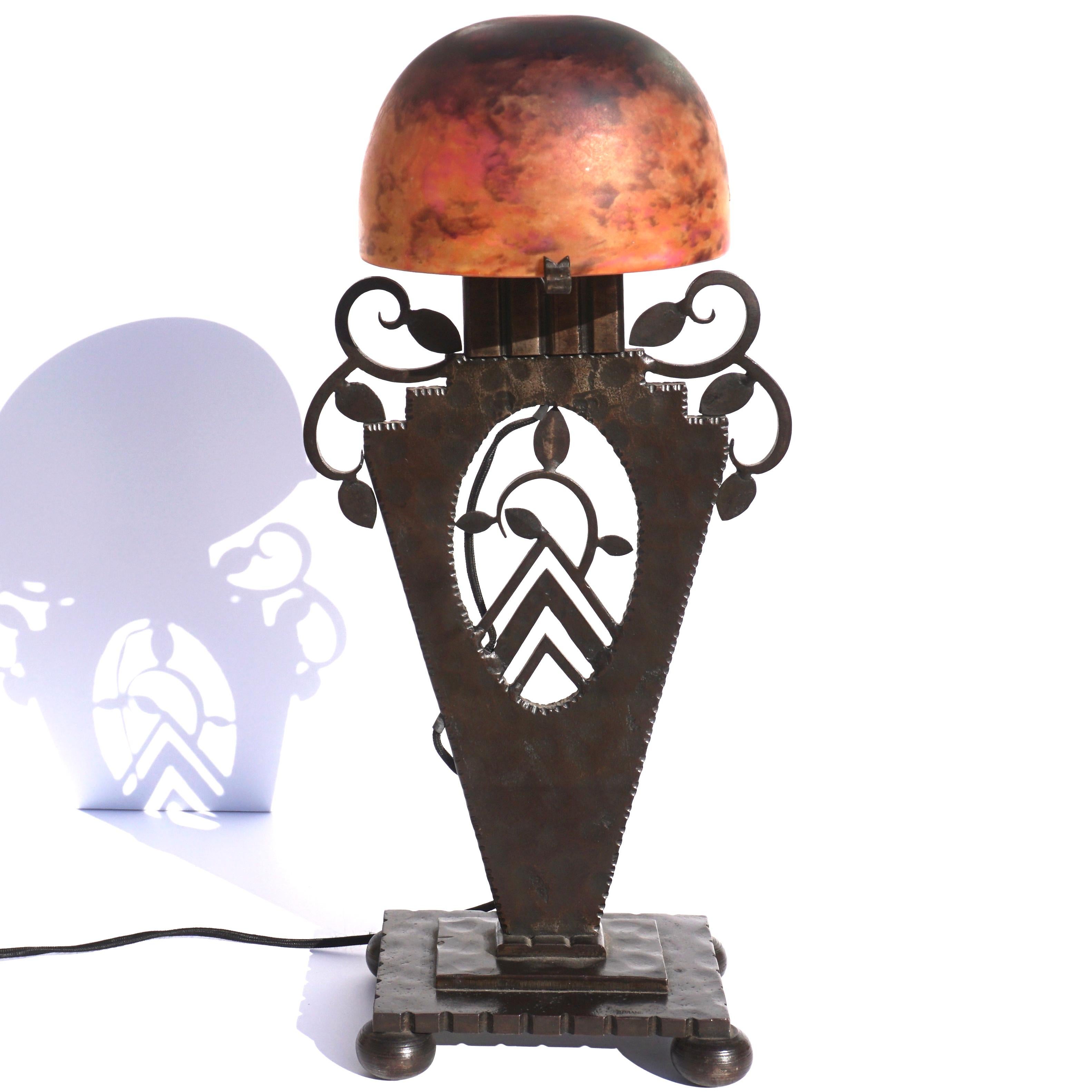 Daum Freres Nancy; Edgar Brandt, Table light, circa 1925, 

Daum Nancy shade is variegated and mottled art glass with powder fusions of, white, orange, red and violet. Wrought, forged iron patinated base has Art Deco decorations of leaves and