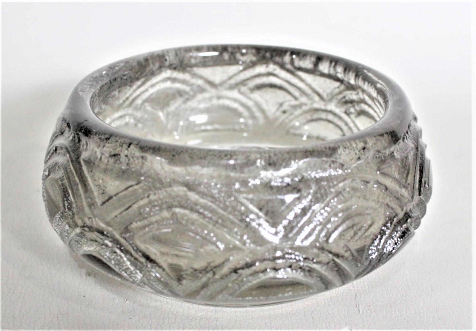 This art glass bowl was done by the renowned French glass maker in approximately 1930 in the period Art Deco style. The grey smoked glass bowl has been deeply acid etched with a stepped crescent design. The bowl is clearly signed 