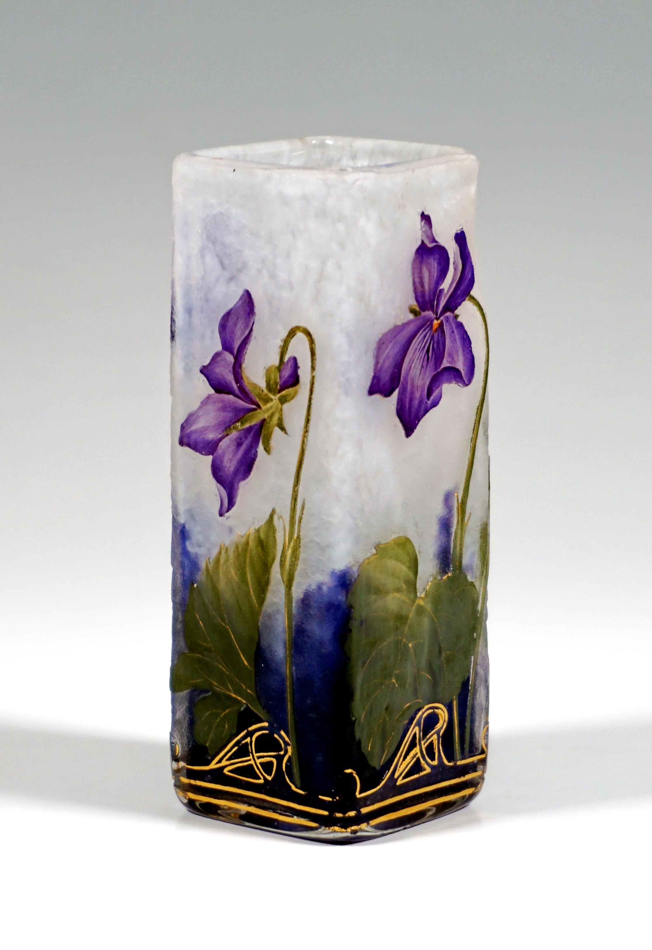 Angular vase on a square floor plan, colorless glass with flaky white, in the stand area with violet powder melts, with etched violet decoration painted in colored enamel with gold heightening and gold decoration, satined surface in the background,
