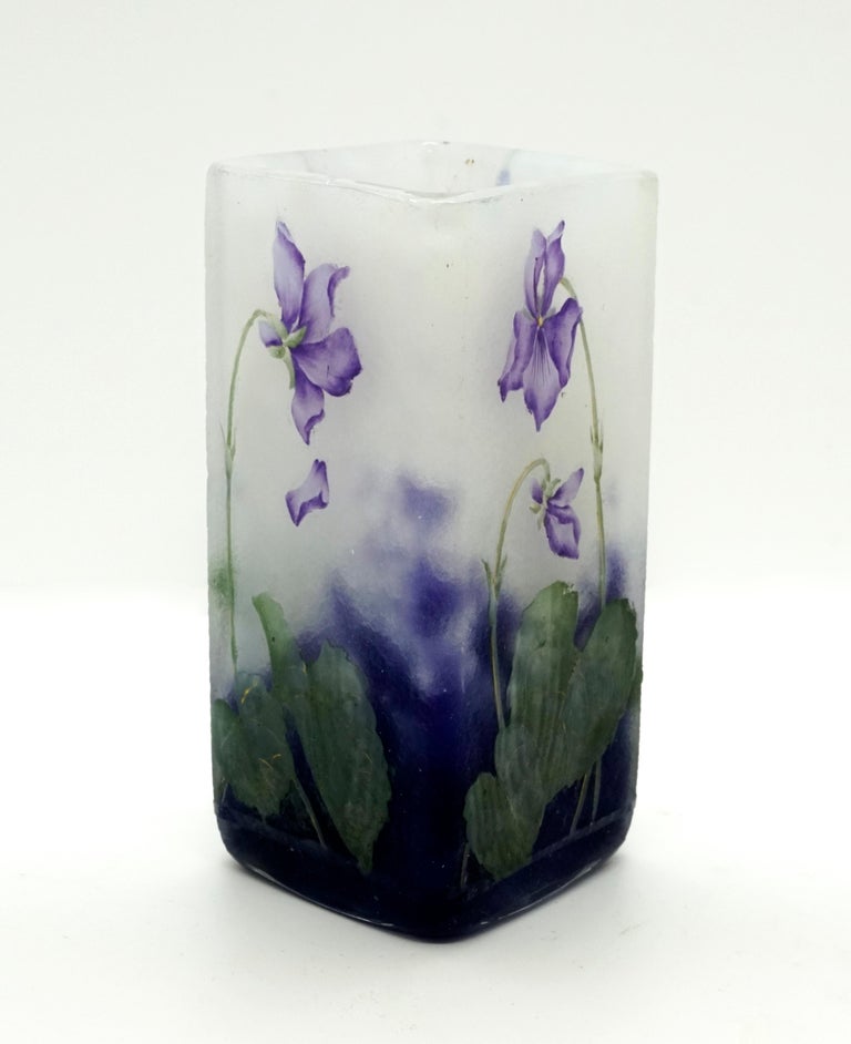 Square vase on a diamond-shaped floor plan, colorless glass with flaky white, in the stand area with violet powder melts, satined surface with etched violet decor painted in colored enamel with gold heightening, relief signature 'Daum Nancy' with