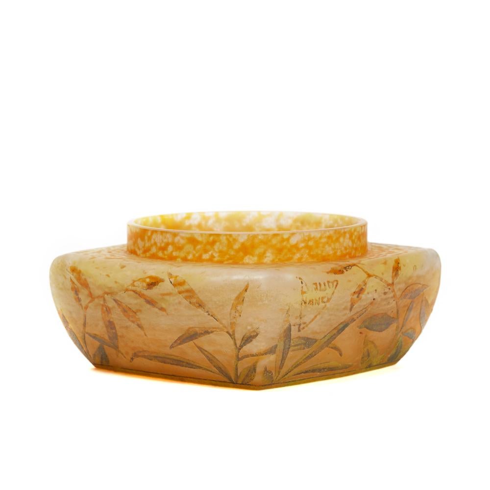 A stunning French Art Nouveau Daum Frères compressed cameo glass square shaped vase wheel cut with raised designs of lily stems in colored enamels on an etched mottled orange ground with a raised cameo 'Daum Nancy' and a croix de Lorraine mark.