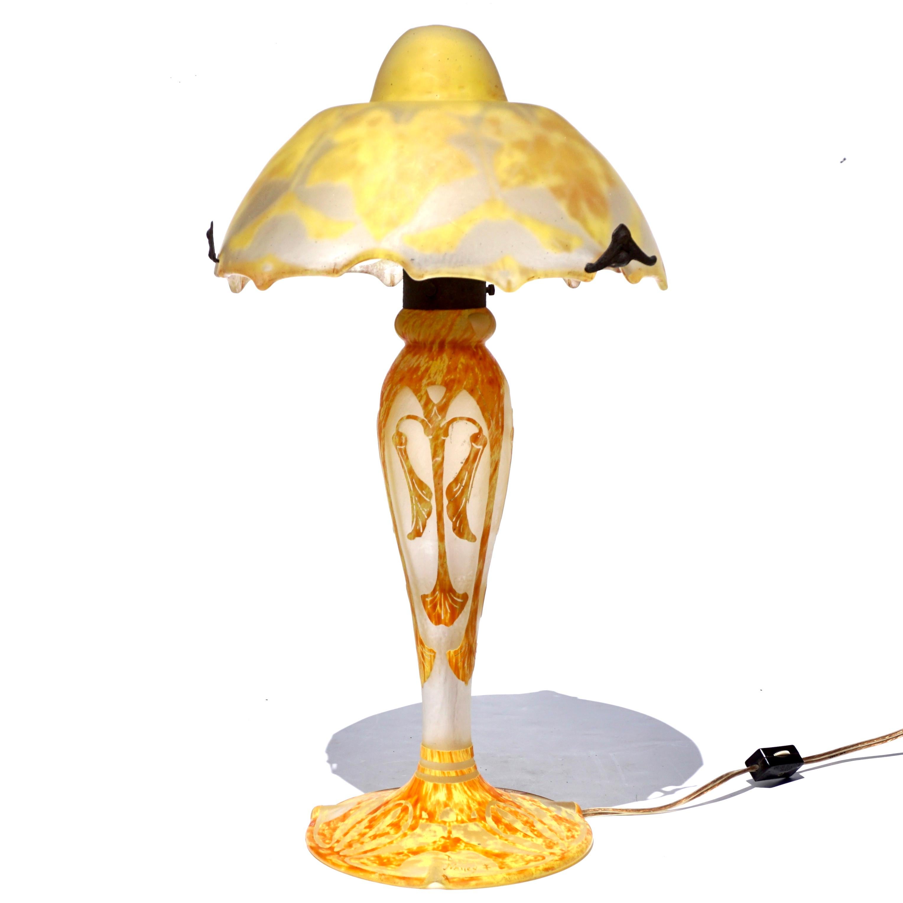 Daum Cameo Glass and Wrought Iron Maple Leaf Table Lamp, circa 1920 Art Nouveau Art Deco design. 

Mottled and variegated glass base with with carved and acid etched Deco symmetrical leaf and seed design signed Daum Nancy with Cross of Lorraine.