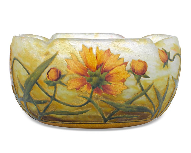 An exceptional French etched and enameled cameo glass bowl by the famed Daum Nancy studios. Decorated in a vibrant wildflower motif with shades of golden yellow, verdant green and rich auburn, this rare vessel is a prime example of the superb