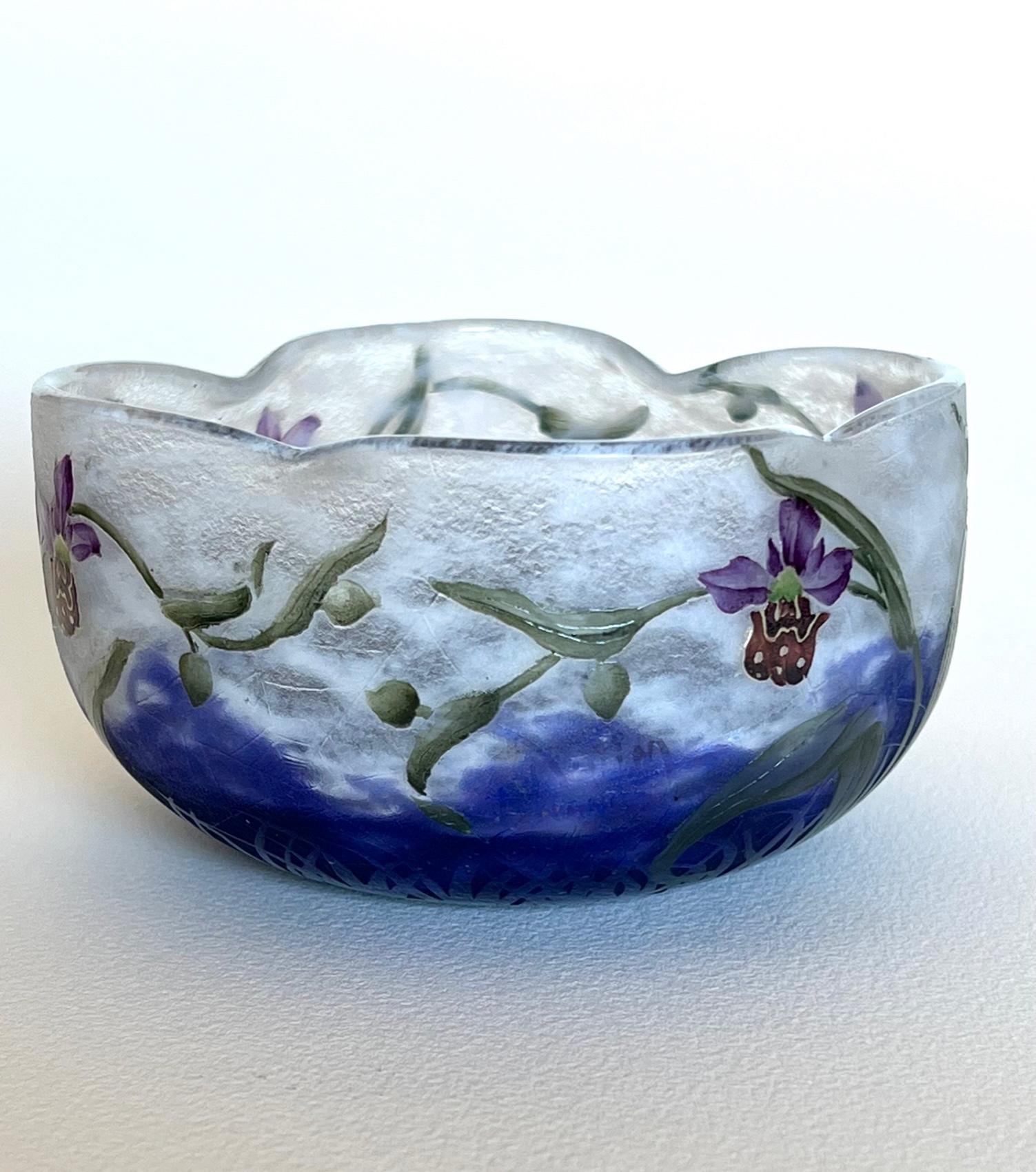 A fine and rare pate de verre cameo glass bowl with a lobed rim. The mottled white ground graduating to a vitrified powdered violet and featuring cameo engraved and polychrome enamelled decoration of ‘Bee Orchids’ with four spiderwebs hung between