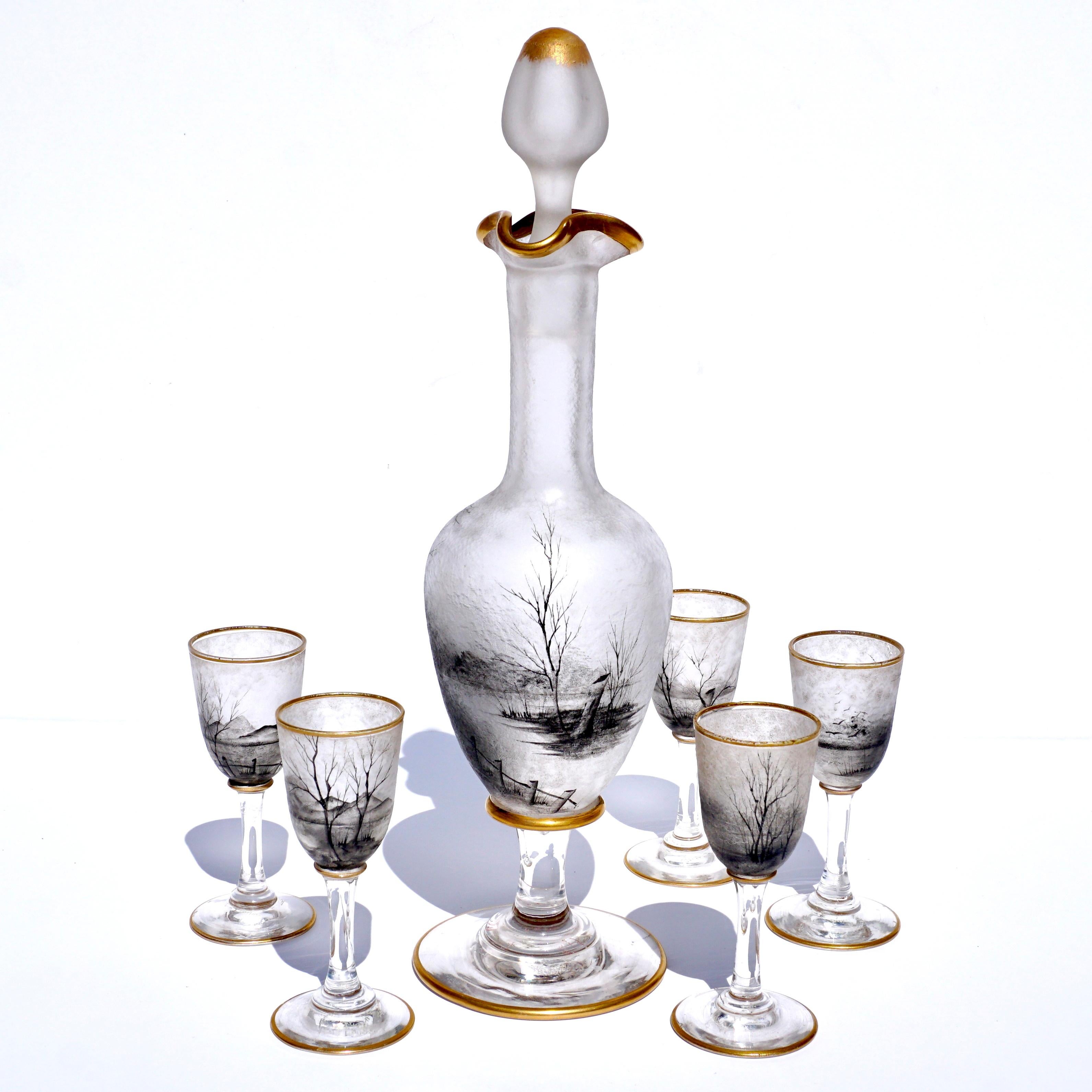 A spectacular Art Nouveau cordial set signed Daum Nancy with Cross of Lorraine. French Cameo Art Glass Frosted with white background. Acid etched with black enamel scenic decor consisting of farm houses, meadows and trees. Gold gilt trim on upper