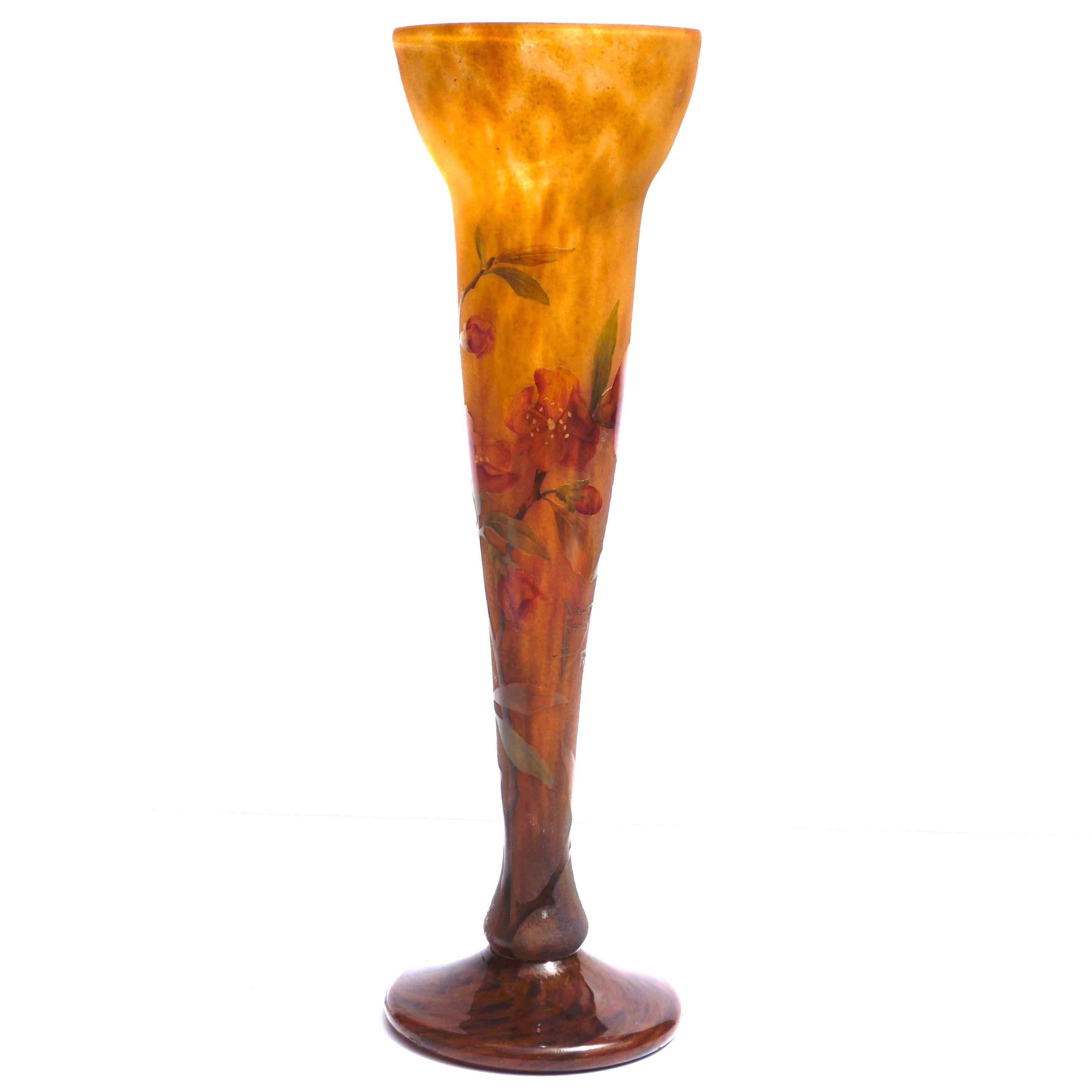 A magnificent Acid etched and enameled Daum Nancy vast standing at 14.25 Inches tall. Superb red exotic flowers with green leaves on brown stems are raised by wheel carving and acid etching upon the yellow and orange variegated background. A