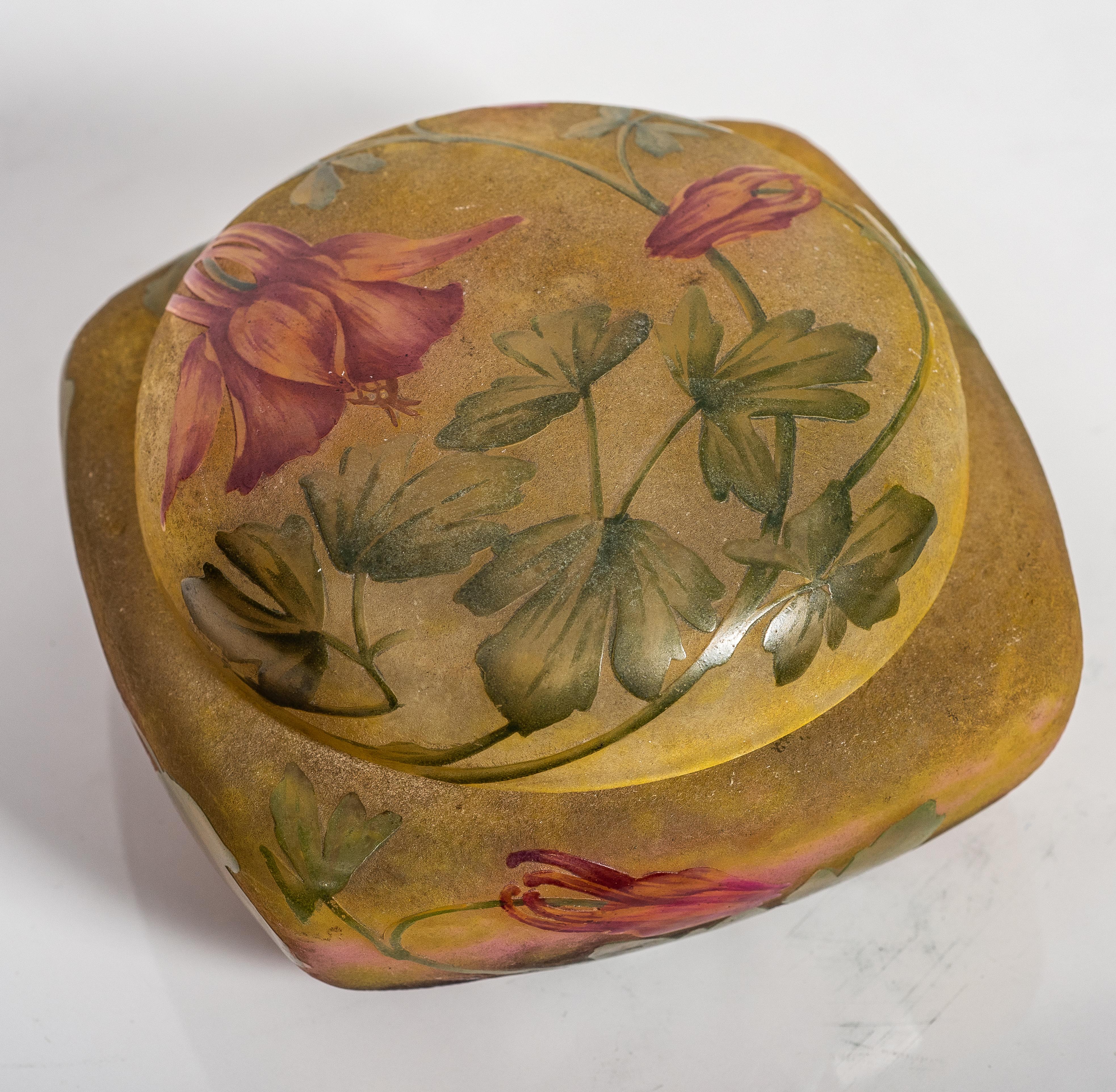Daum Nancy enamelled and internally decorated glass box and cover, 
France, circa 1900-1910
decorated with red wild flowers and green leaves on a mottled green and brown ground.
signed with cameo mark Daum Nancy with Lorraine cross
DIMENSIONS