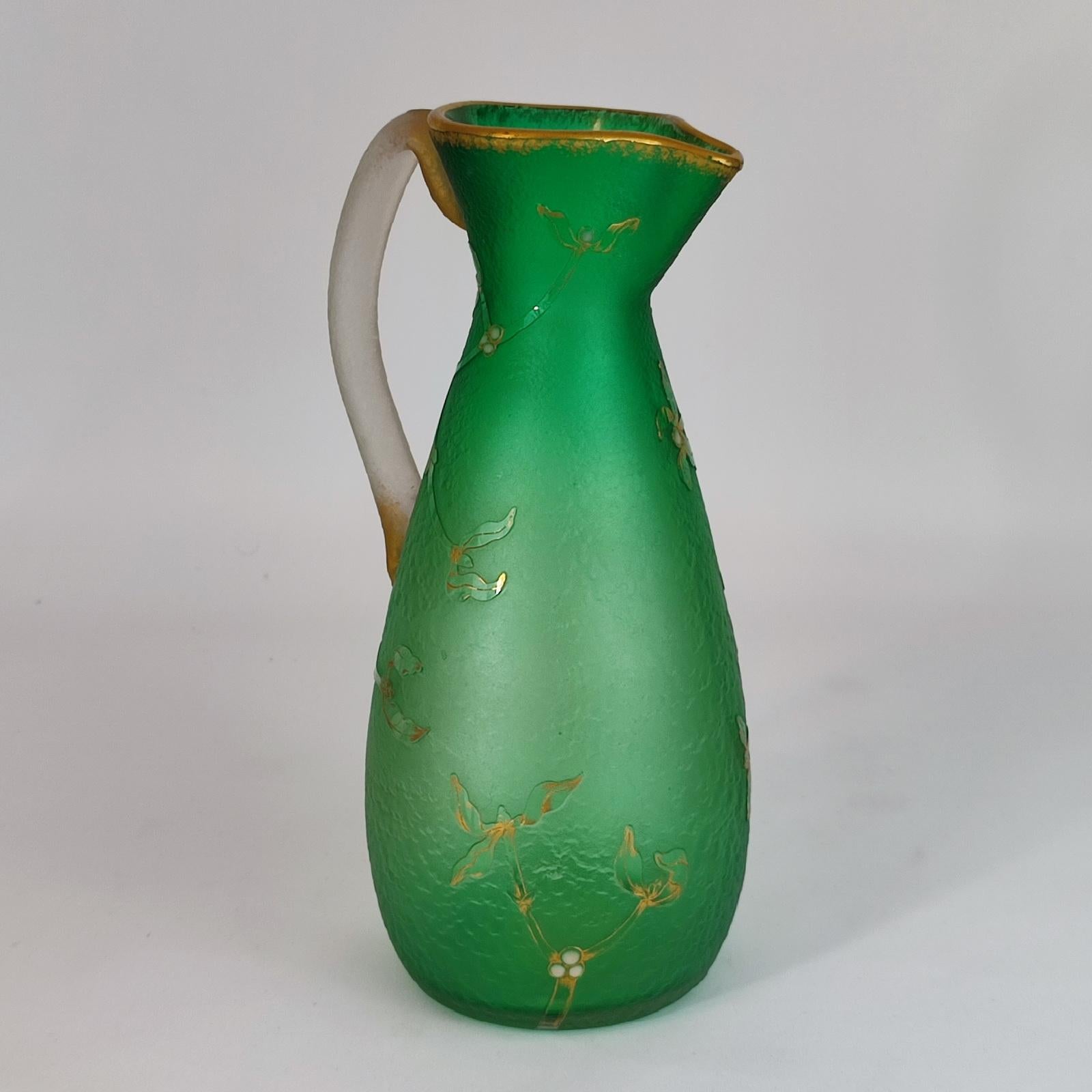 Daum Freres, Nancy, France, late 19th century large pitcher. An exquisite Art Nouveau glass vase/pitcher by Daum Nancy, roughened acid etched surface with gilt and white enameled mistletoe overlay, the base signed in gilt lettering 