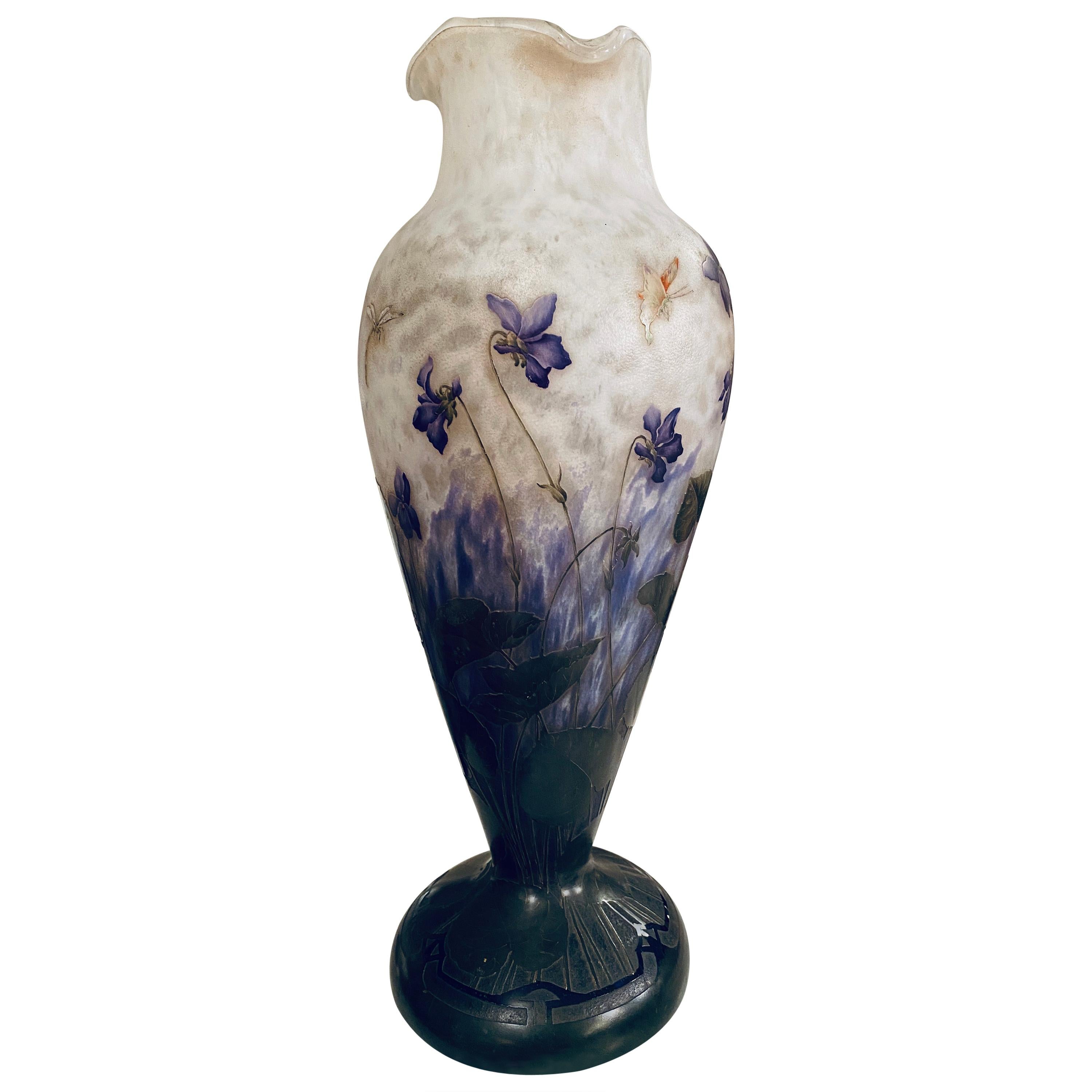 Important baluster vase with a lively collar in multilayered glass with a rotating decoration engraved on the wheel and acid with polychrome enamels of violets, butterfly and dragonfly on a white marmoreal base. Measure: Height 49 cm.
Signature