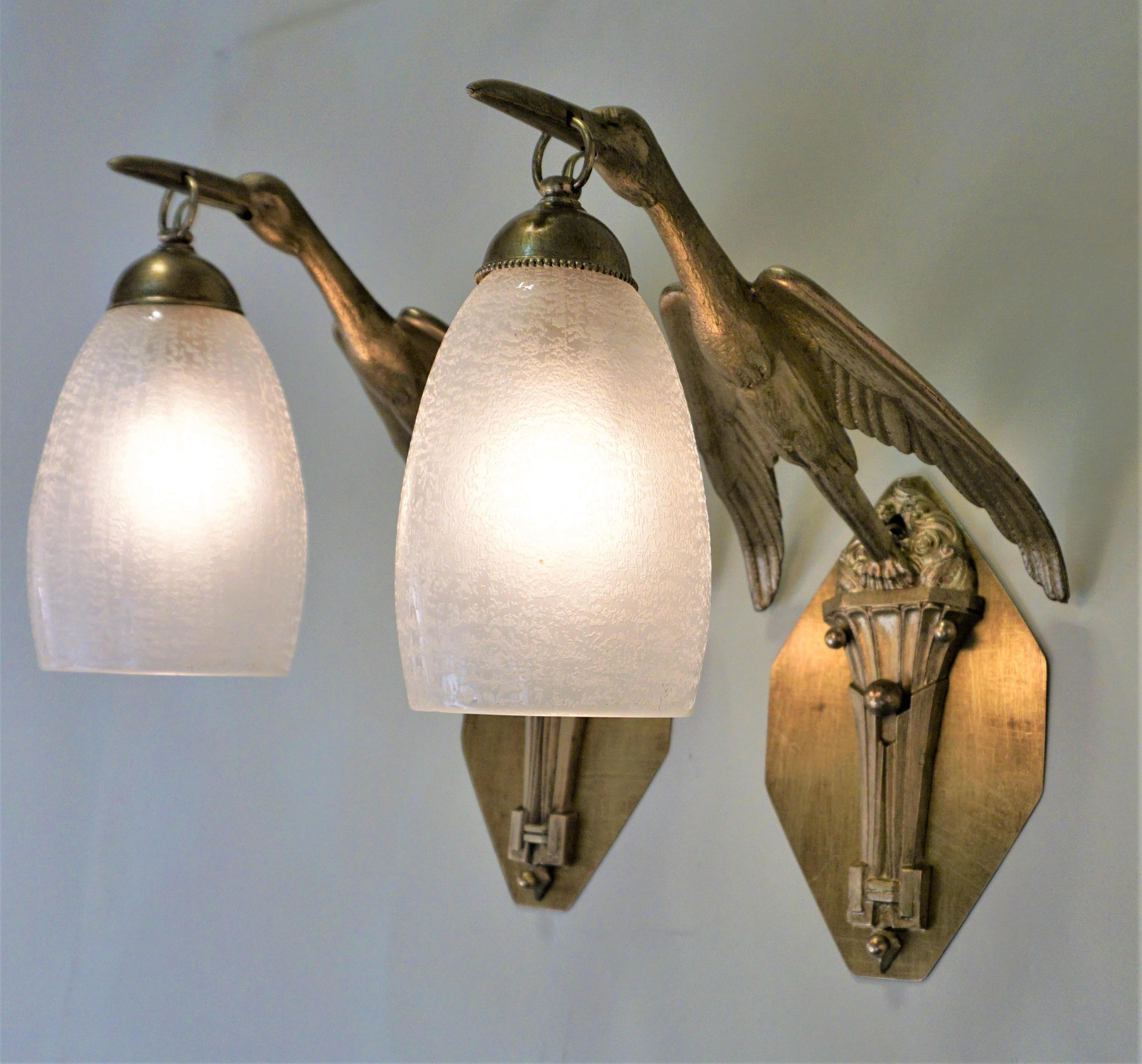 Pair of bronze bird in flying motion and Daum acid texture glass shade wall sconces.