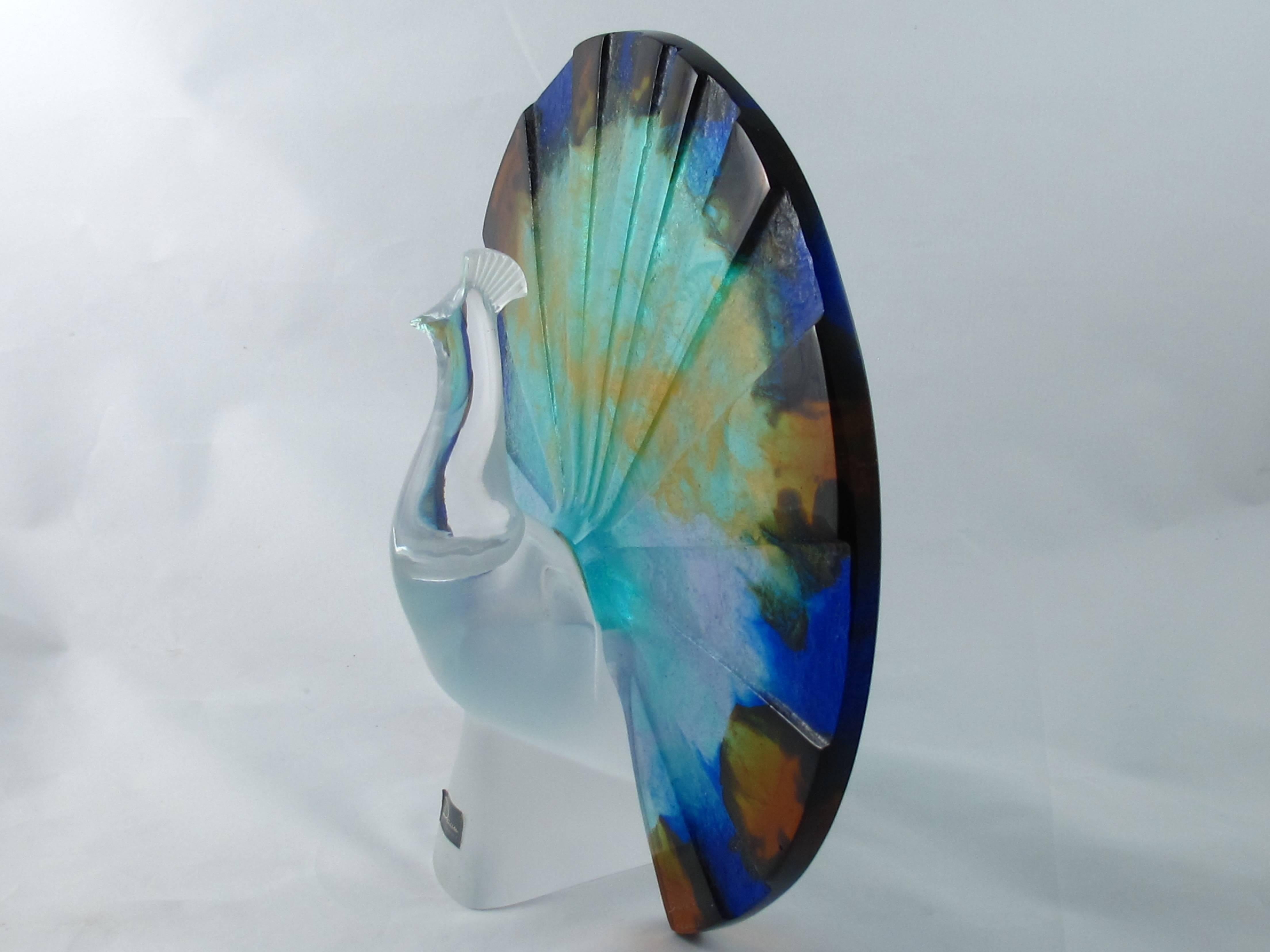 Daum peacock glass sculpture. The feathers made of transparent, etched and multicolored pate-de-verre glass and the body made from clear crystal glass. Designed and made by Daum in France in the 1980s. It is signed Daum France on the lower right. IT