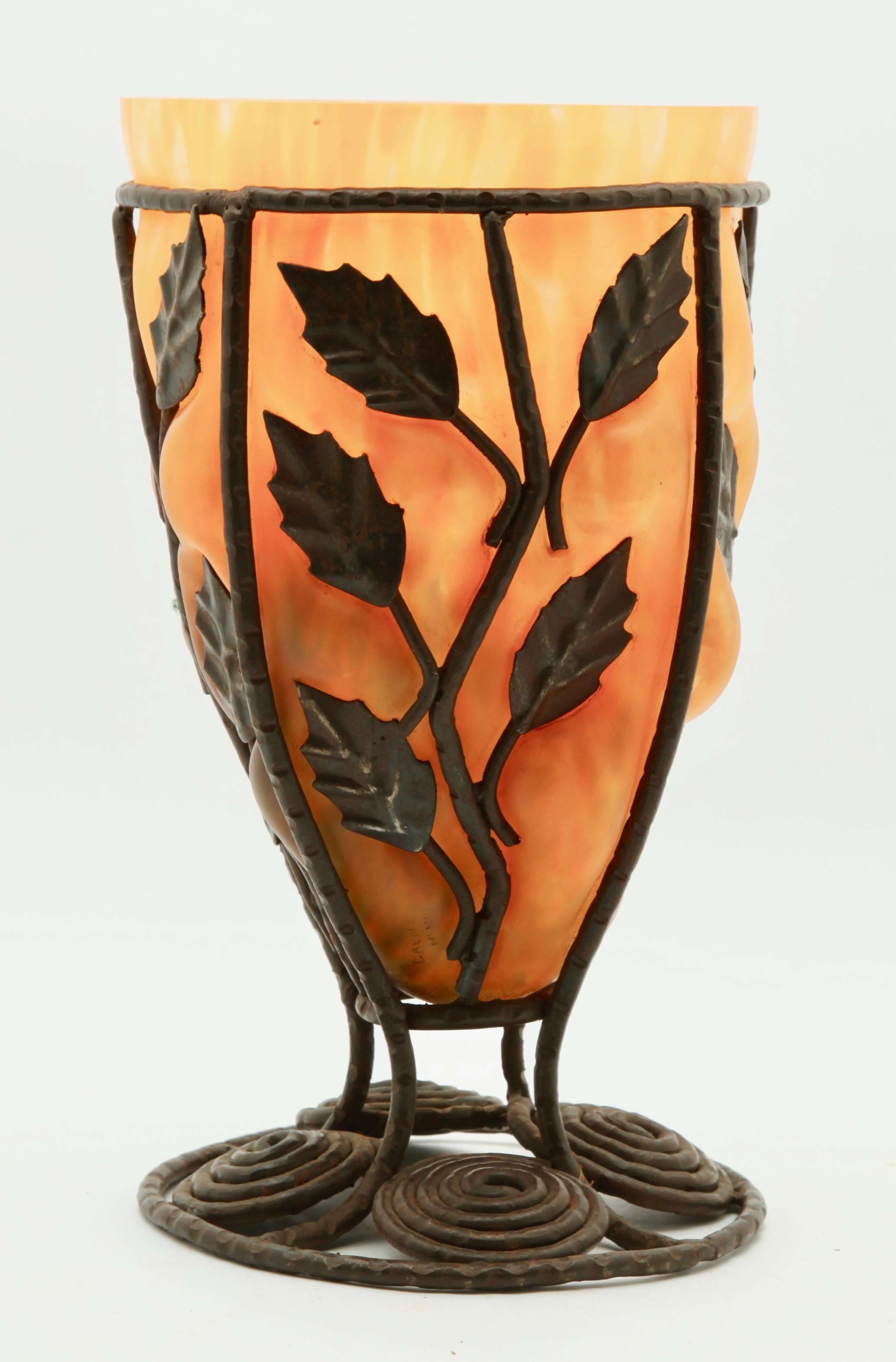 This Art Deco style glass vase, Daum (signed) blown out into wrought metal frame with organic swirls, tree branches and leaves, is done in the style of Louis Majorelle for Daum
Measures: 11.7 by 6.5 inches (29.8 by 16.5 cm).
Condition is good.
There