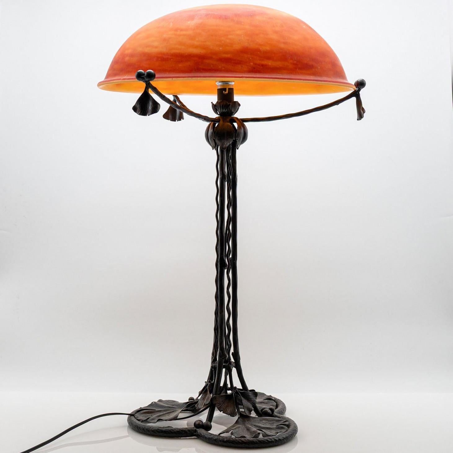 Esta exquisita lámpara de sobremesa Art Nouveau de hierro y cristal naranja es todo un reclamo. Fabricado por Daum en Nancy, Francia.

Una impresionante lámpara de sobremesa, de diseño clásico, inspirada en formas orgánicas y naturales.

Daum es un