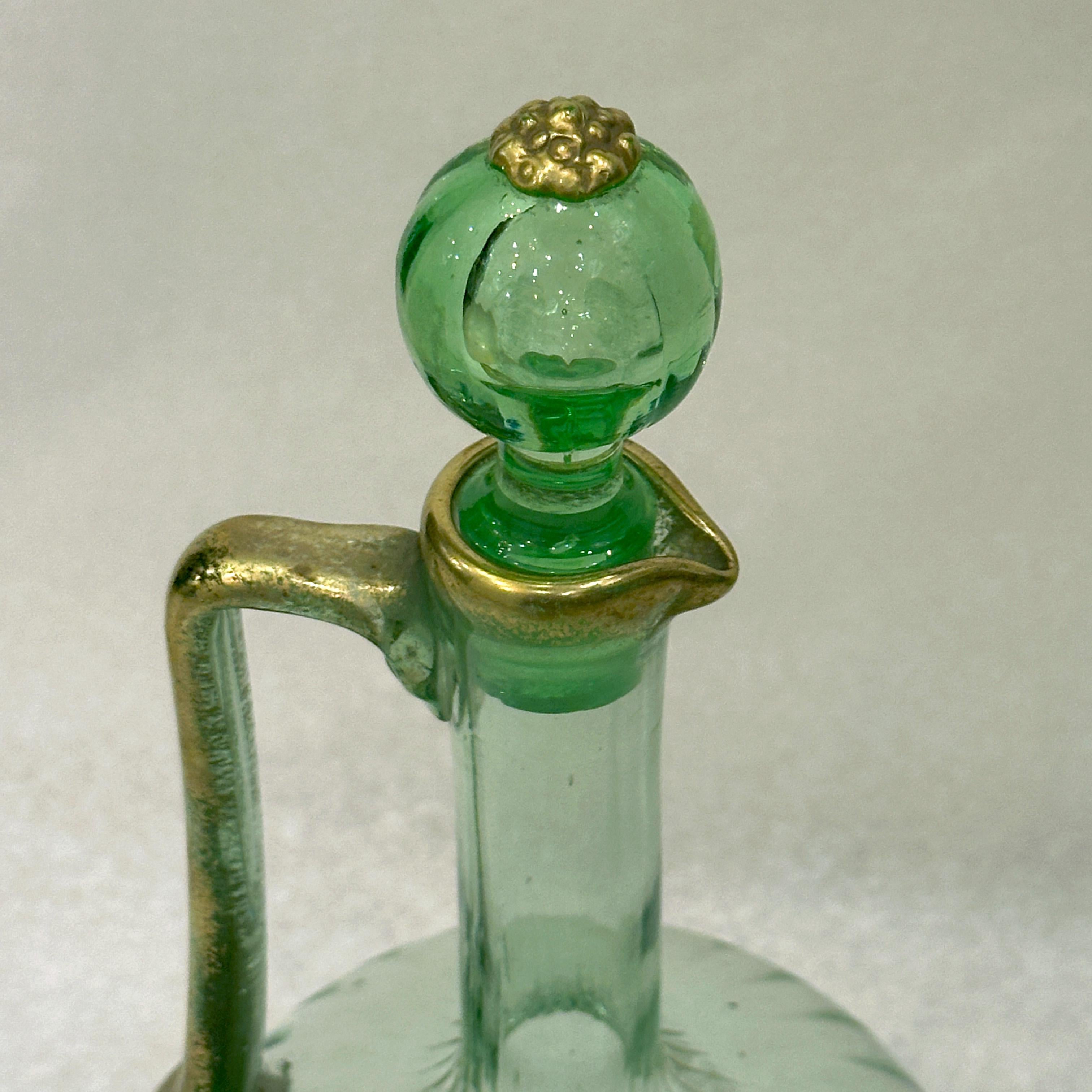 Questo decanter per vino in vetro soffiato color verde smeraldo riflette l'eccezionale savoir-faire della manifattura Daum di Nancy intorno al 1900. Il suo corpo a coste aggiunge una texture dinamica, mentre gli eleganti accenti d'oro - applicati
