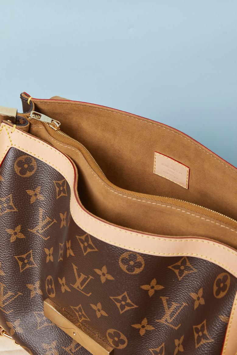 Borsa DAUPHINE in pelle monogramma con tracolla a catena staccabile. Lunghezza della catena = 66 cm. Sacchetto antipolvere in dotazione. Chiusura a calamita sotto la patta superiore. Una tasca interna con chiusura a zip. 
DIMENSIONE: 30cm X 22cm X