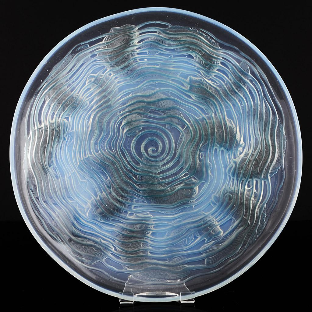 'Dauphins' an opalescent glass plate by Rene Lalique decorated over with reverse raised motif of stylised dolphins swimming through ripples of water. Signed R Lalique France to centre. Excellent original condition.

Literature: Marcilhac Catalogue