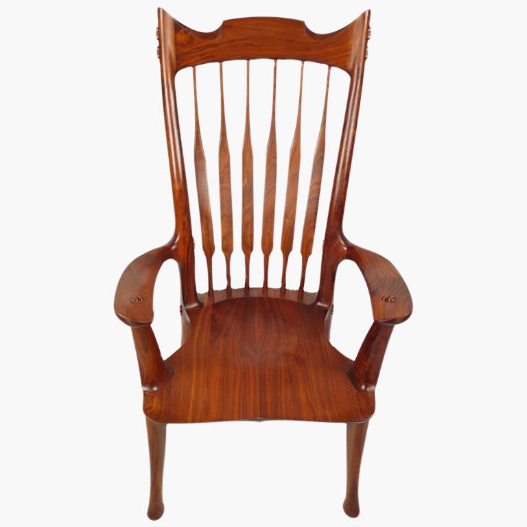 American-craft hand-carved walnut arm chair designed and fabricated by David Hentzel who was an apprentice to Sam Maloof and worked in his studio for a time. This chair is not a copy of Maloof design but is constructed in the in the same masterful