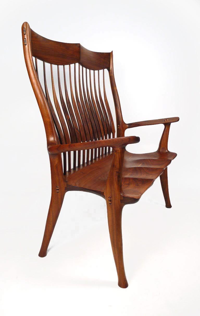 American-craft hand-carved walnut settee designed and fabricated by David Hentzel who was an apprentice to Sam Maloof and worked in his studio for a time. This settee is not a copy of a Maloof design but is constructed in the same masterful language