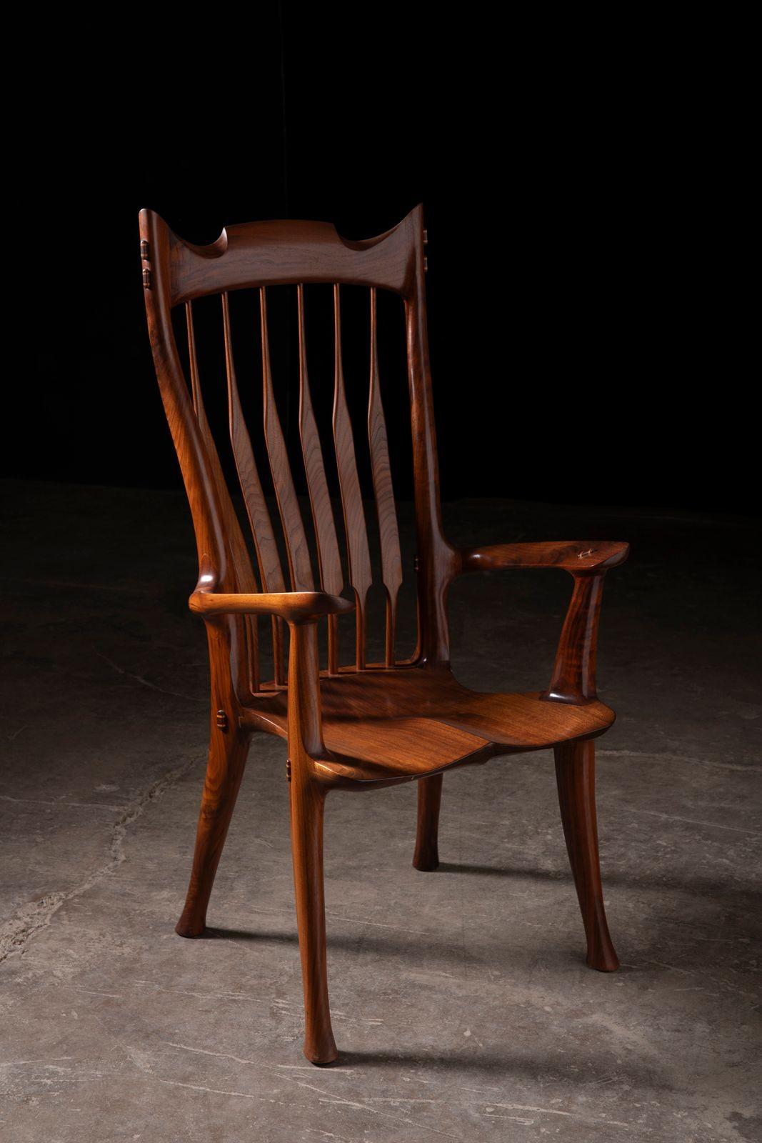 A stunning studio-crafted armchair in richly figured claro black walnut, designed and built by American craftsman Dave Hentzel—an admirer of Sam Maloof and a torchbearer of the American studio furniture tradition. This chair embodies the sculptural