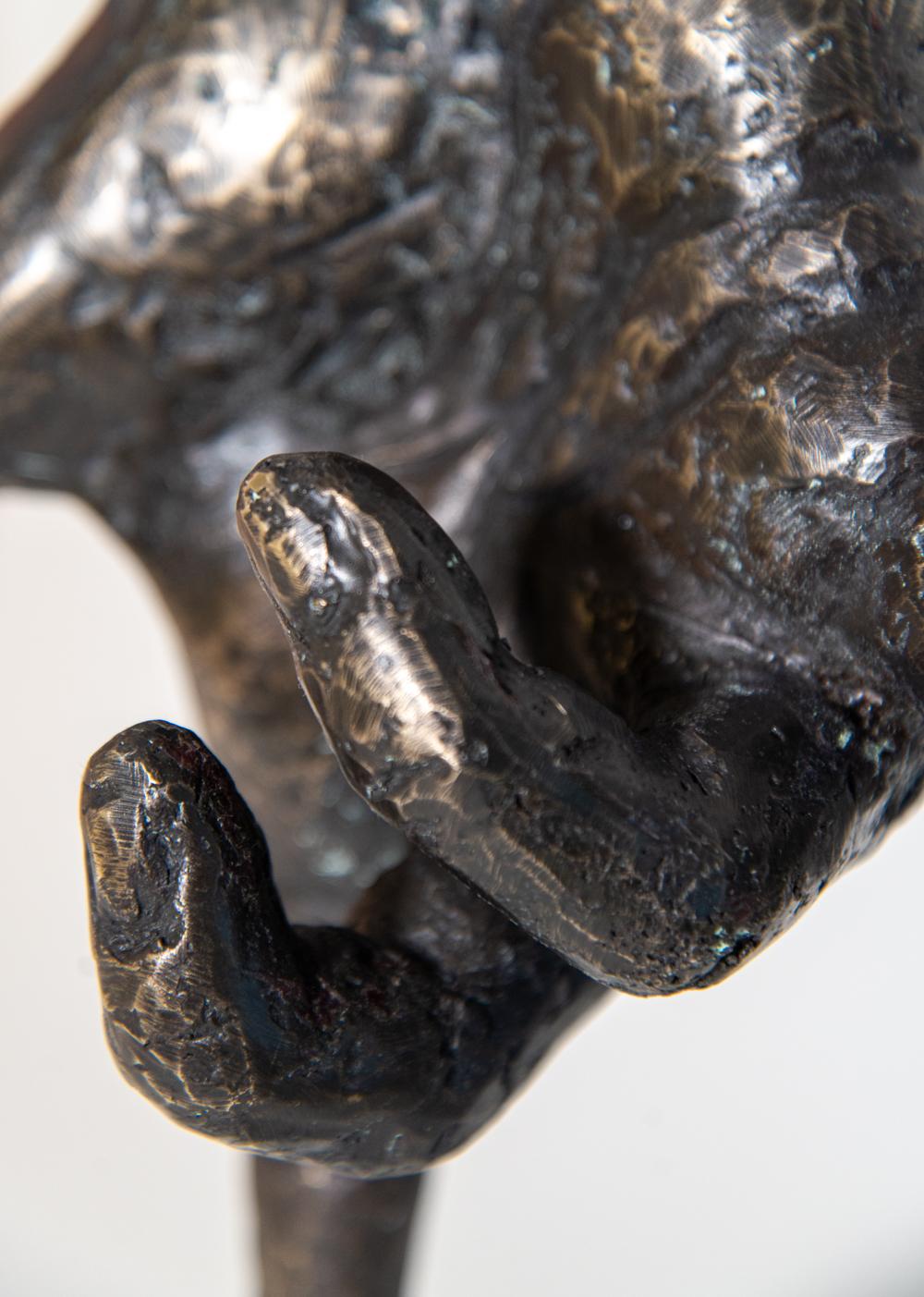 Une main en bronze, modelée d'après celle de l'artiste, se tient en équilibre sur son index au sommet d'une sphère dans cette sculpture pop art imaginative de Dave Sheridan. Intitulée 