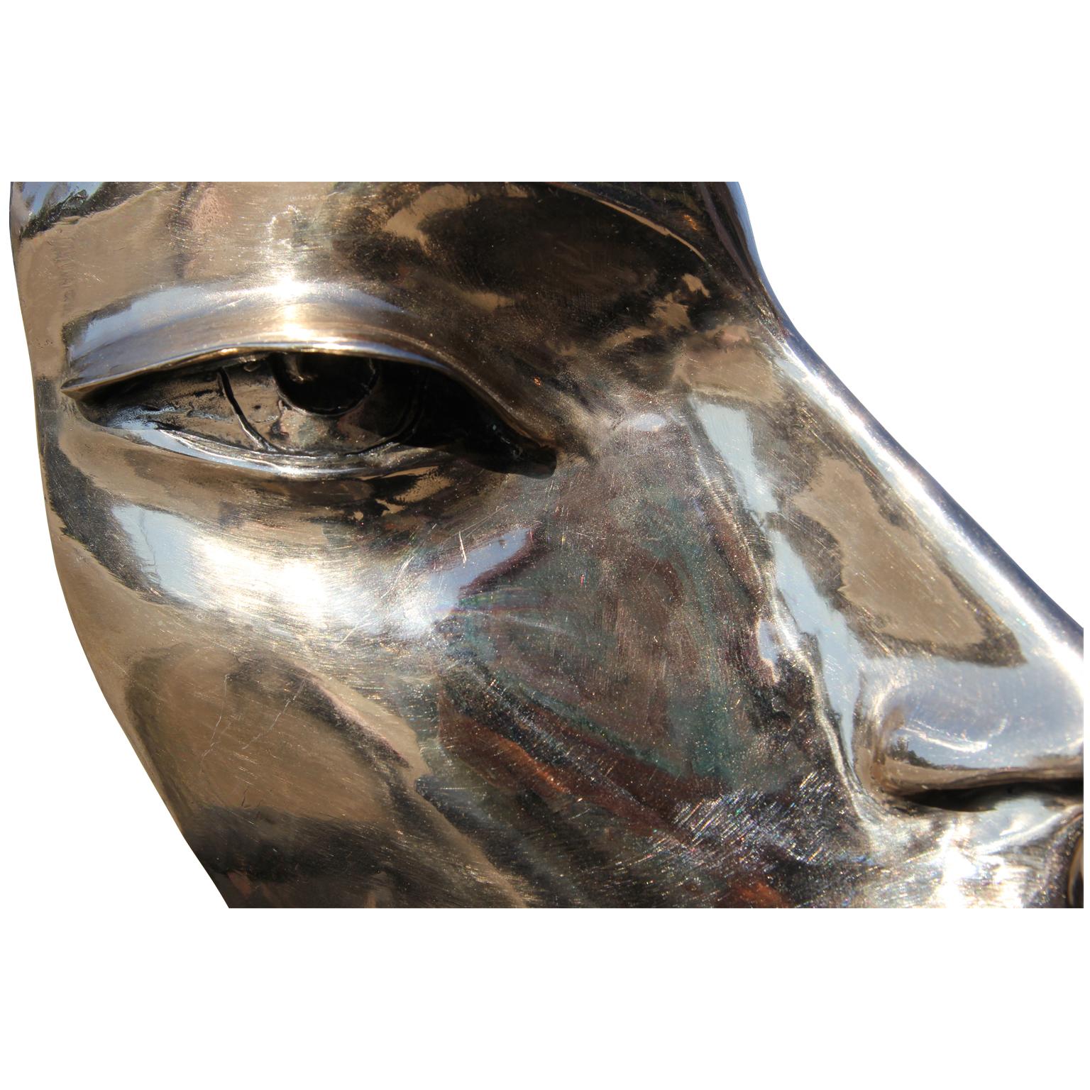 Moderna escultura abstracta de bronce en forma de busto retrato del artista David Adickes, de Houston, Texas. La obra está modelada a partir de una amiga de Adickes, Julie Burrows, y presenta rasgos faciales afilados y montados sobre una base de