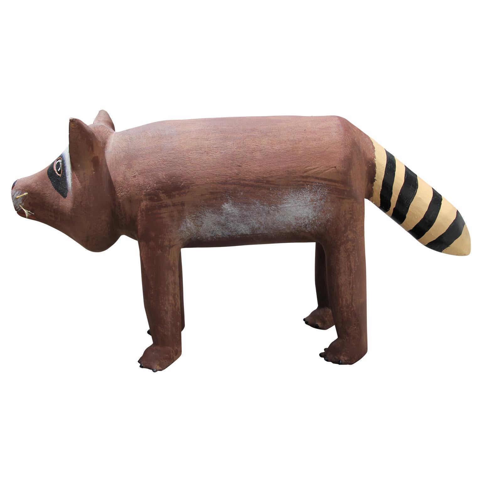 Modern wooden racoon sculpture by folk artist David Alvarez. Carved by hand and then meticulously painted, the sculpture also features natural fiber whiskers. Signed underneath by the artist.

Artist Biography: David Alvarez (1953–) discovered his