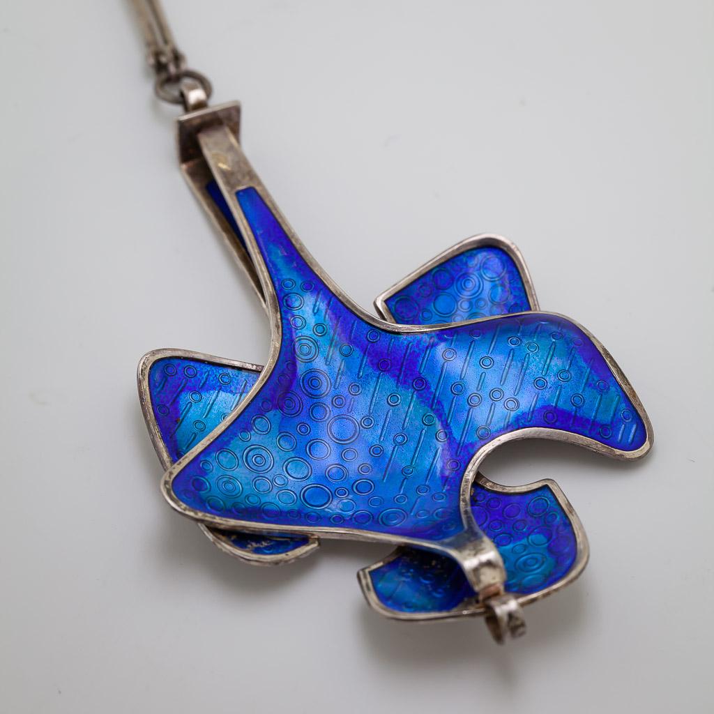 THIS BEAUTIFUL TRANSLUCENT BLUE BASSE-TAILLE ENAMEL ON A STERLING SILVER MODERN ABSTRACT
REVERSIBLE SHAPPED PENDANT, 
95.6 X 60.4 X 7.5 MM, 
BACK MARKED DAVID-ANSERSEN, NORWAY
STERLING 925S, 
INV.B.S.O., SUSPENDED FROM A STERLING SILVER BAR LINK,