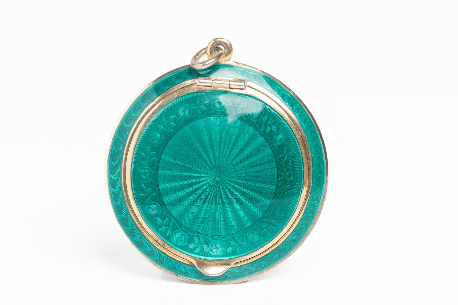 This exquisite and rare art deco sterling silver and teal guilloche enamel mirror compact was made by world-renowned designer and silversmith David Andersen. The exterior of the compact has a sunrise motif in the center of the piece with an enamel