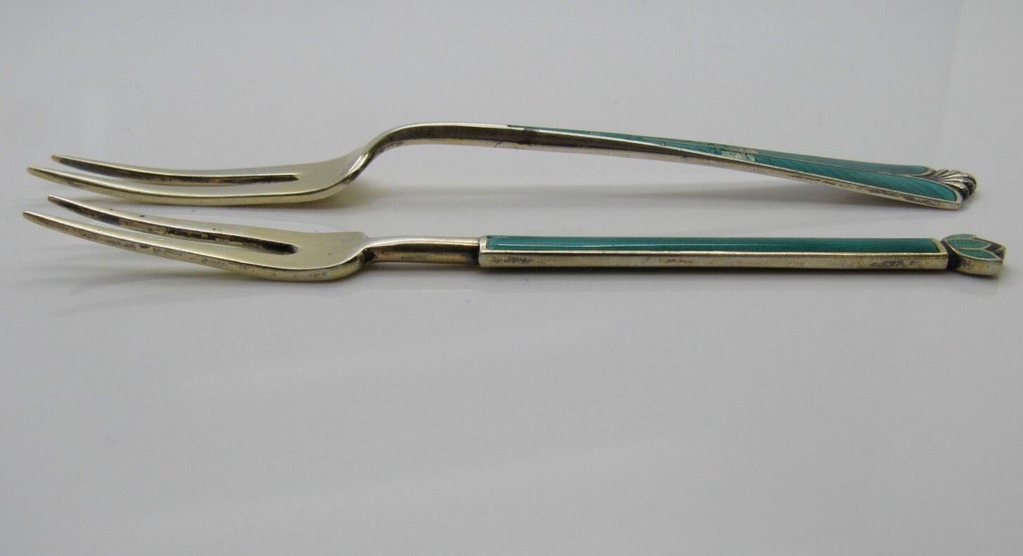Set of 2 David Andersen Norway gold washed sterling silver green enamel lemon and pickle forks.

The smaller fork is a lemon fork featuring a green enamel handle topped with a flower. The larger fork is a pickle fork in the green enamel City Hall