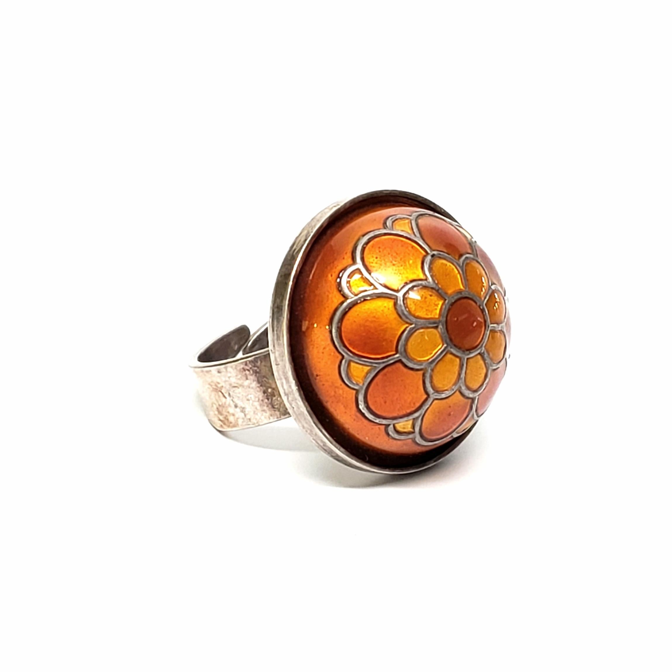 Sterling silver and orange enamel dome ring by David Andersen.

This David Andersen ring features a large orange enamel ring with a floral design. Adjustable size 7.

Dome measures approx 22.8mm (approx 7/8