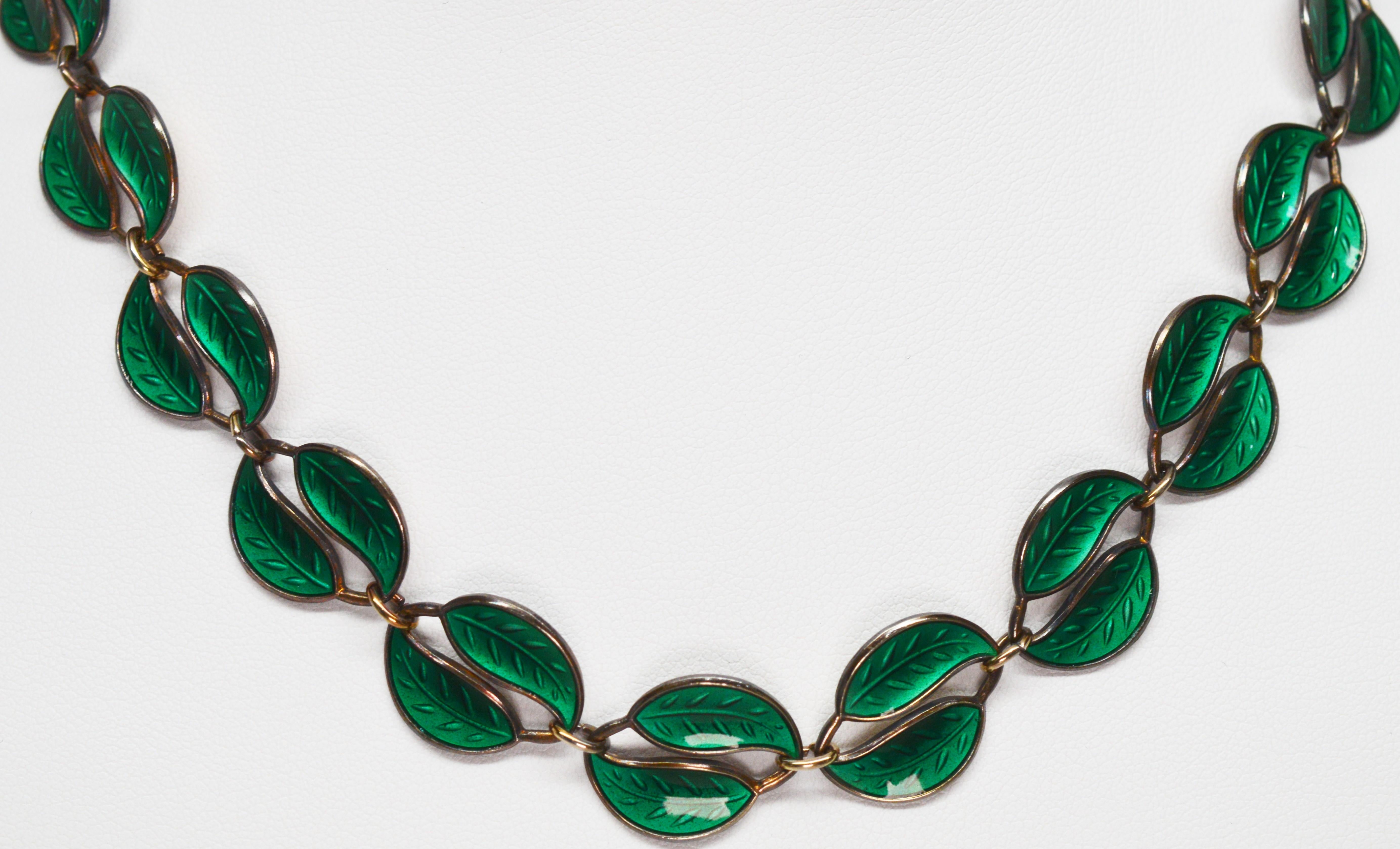 Twenty two panels of vibrant emerald green petals seamlessly linked together create this striking circa 1950's artisan sterling silver necklace created by Willy Winnaess, key designer for Norwegian Goldsmith David Andersen, a maker synonymous with