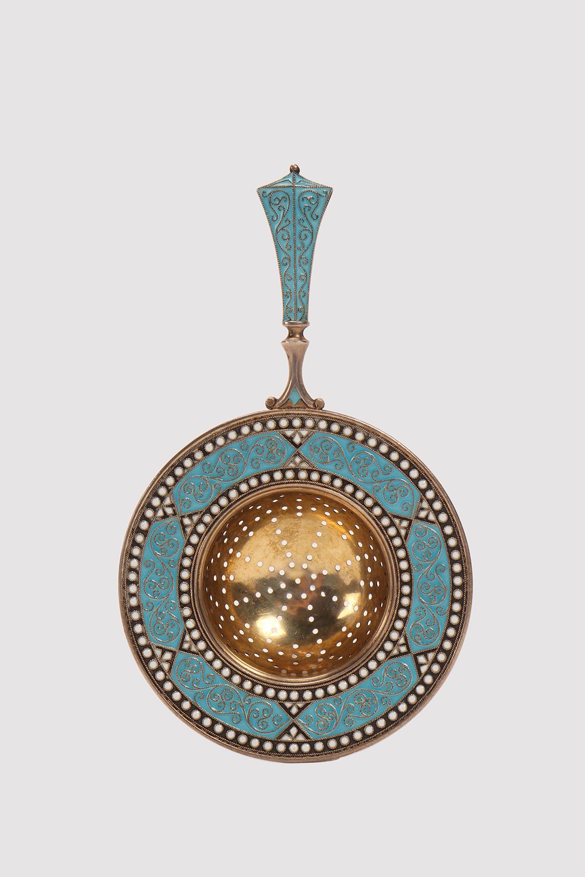 Tea strainer with handle, in gilt silver and geometrical decoration, with blue and white cloisonne enamels. Work of the famous silversmith David Andersen, house founded in 1876. Christiana, Denmark circa 1900.