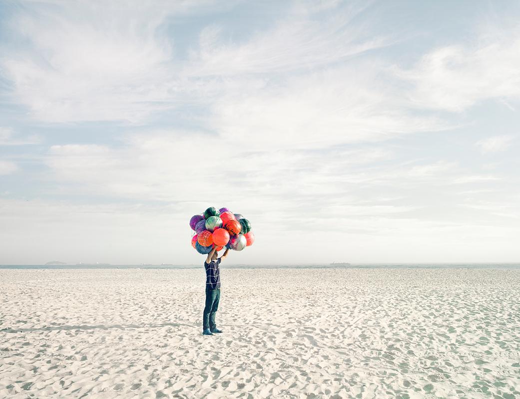 Title: Beach Ball Salesman, Copacabana Beach, Rio de Janeiro, Brazil
All available sizes &amp; editions for each size of this photograph:
21” x 26” Edition of 7 + 2 Artist Proofs
32” x 40" Edition of 7 + 2 Artist Proofs
44” x 55” Edition of 10 + 2