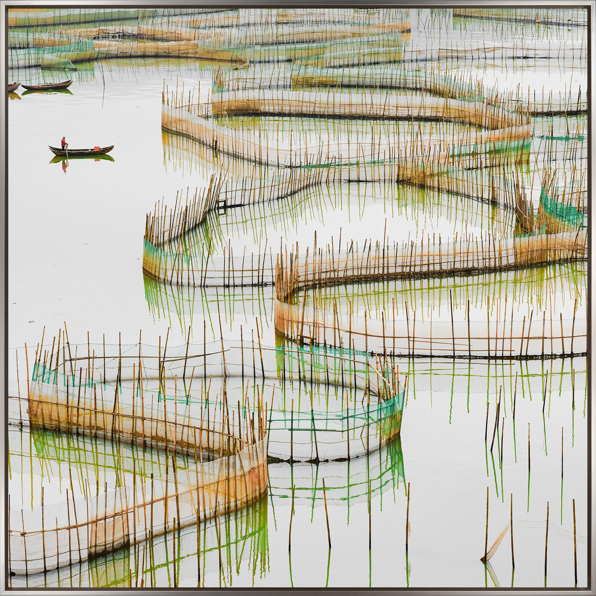 "Nets Study 8" is a framed photograph on aluminum by David Burdeny, depicting small boats amid shallow waters in China. The colorful nets zig and zag across the waterscape, evoking both movement and serenity. The image quality is crisp and true to